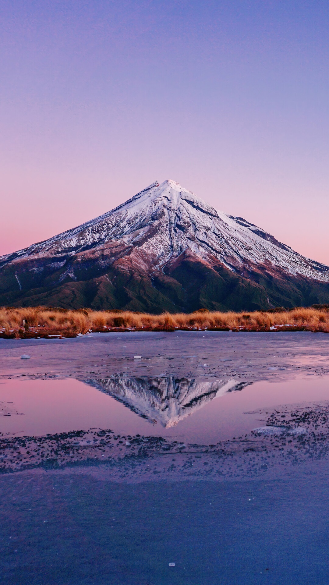 Snow-capped mountain reflected in a frozen lake at sunset HD Phone Wallpaper