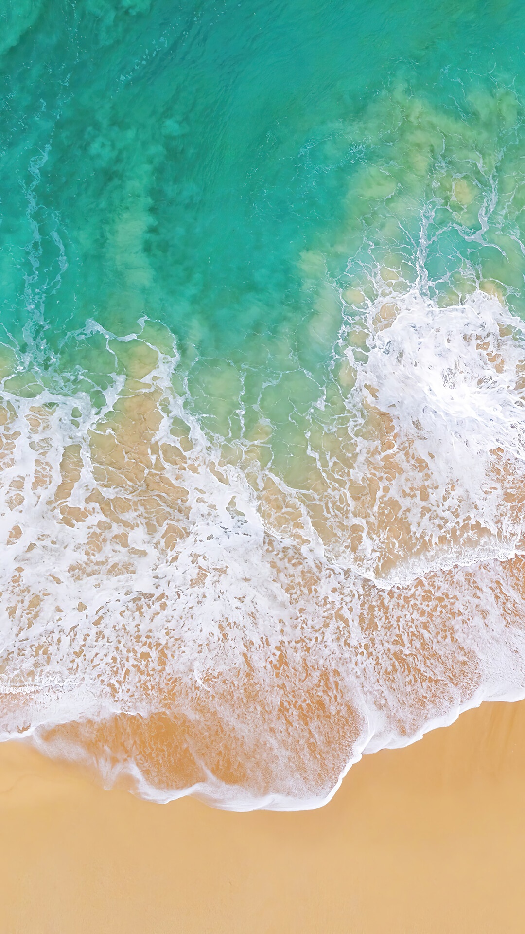 Aerial view of ocean waves crashing on a sandy beach HD Phone Wallpaper