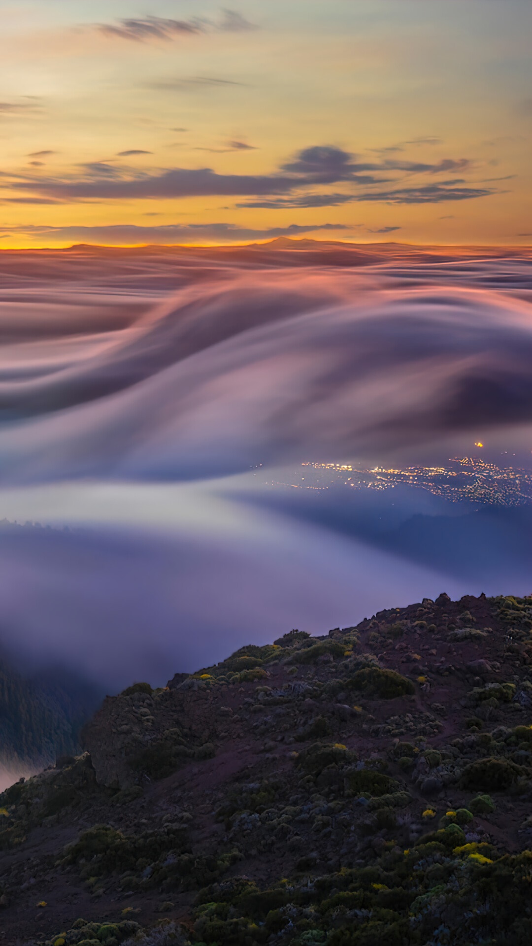 Foggy mountain landscape at sunrise with city lights below HD Phone Wallpaper