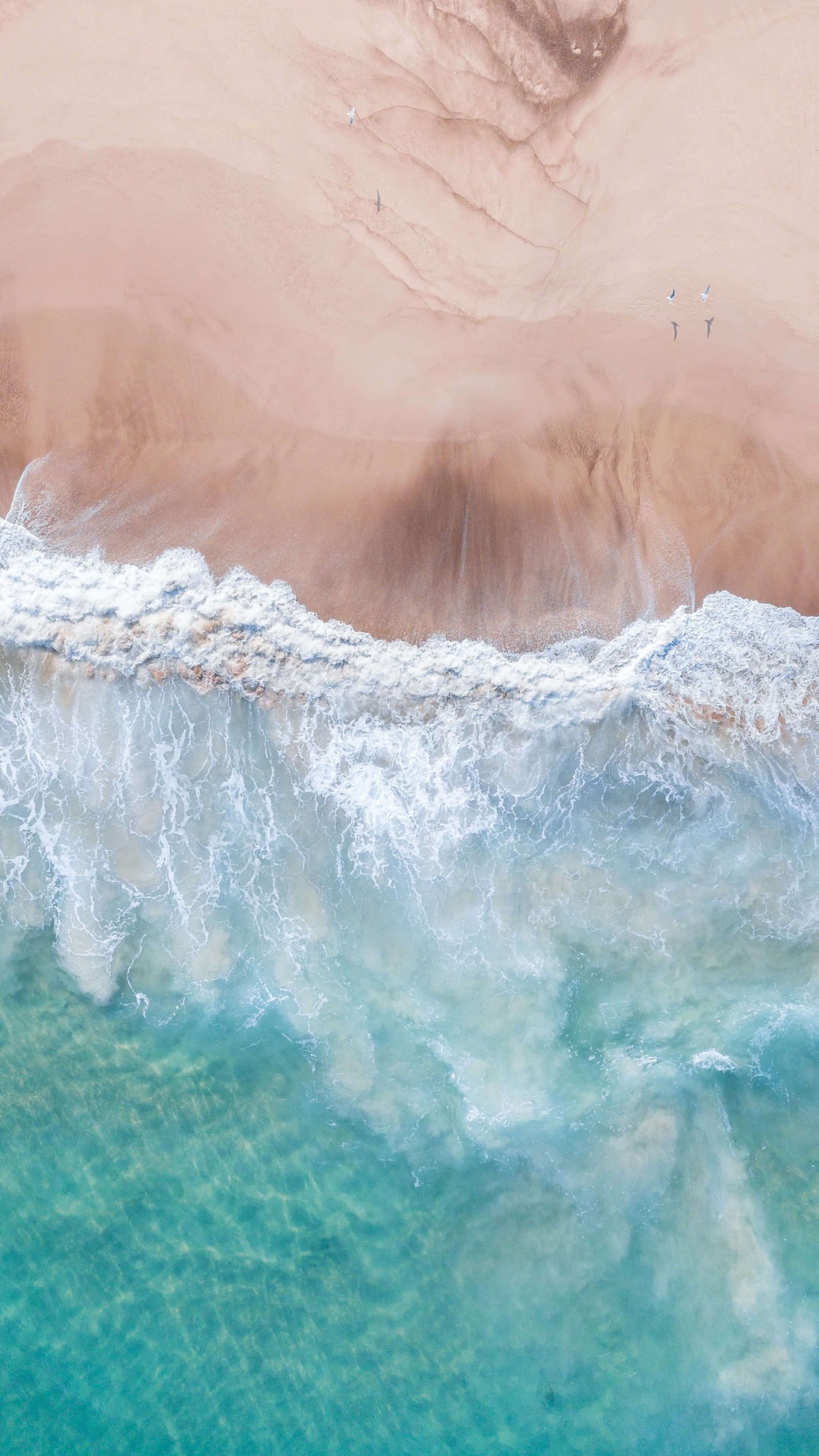 Aerial view of a sandy beach with ocean waves HD Phone Wallpaper