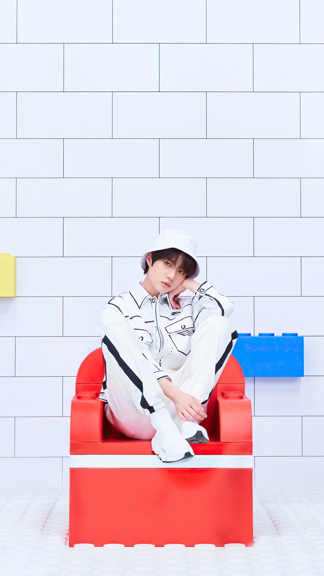 Beomgyu from TXT sitting on a red chair HD Phone Wallpaper