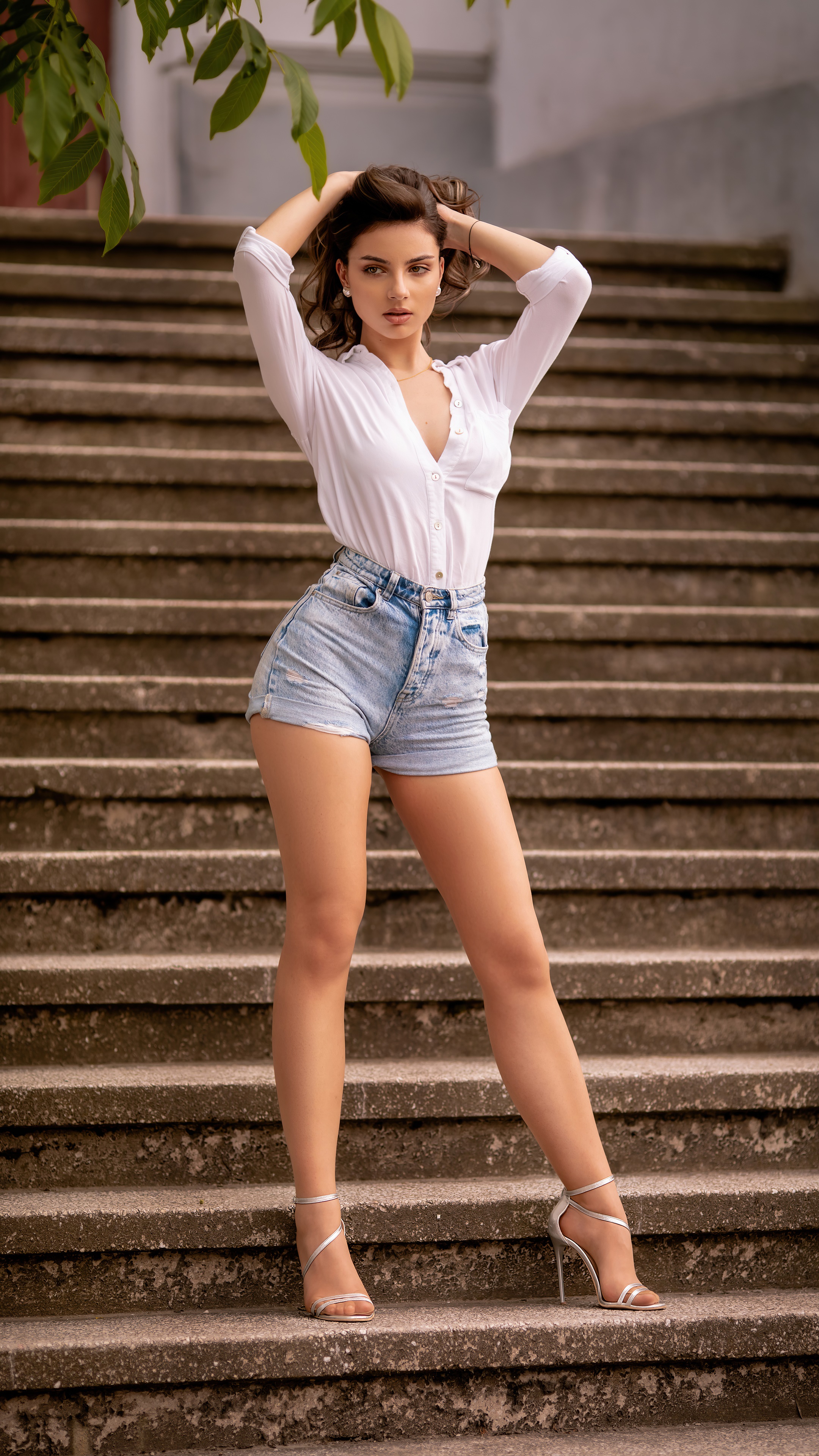 Model in white shirt and denim shorts on stairs HD Phone Wallpaper