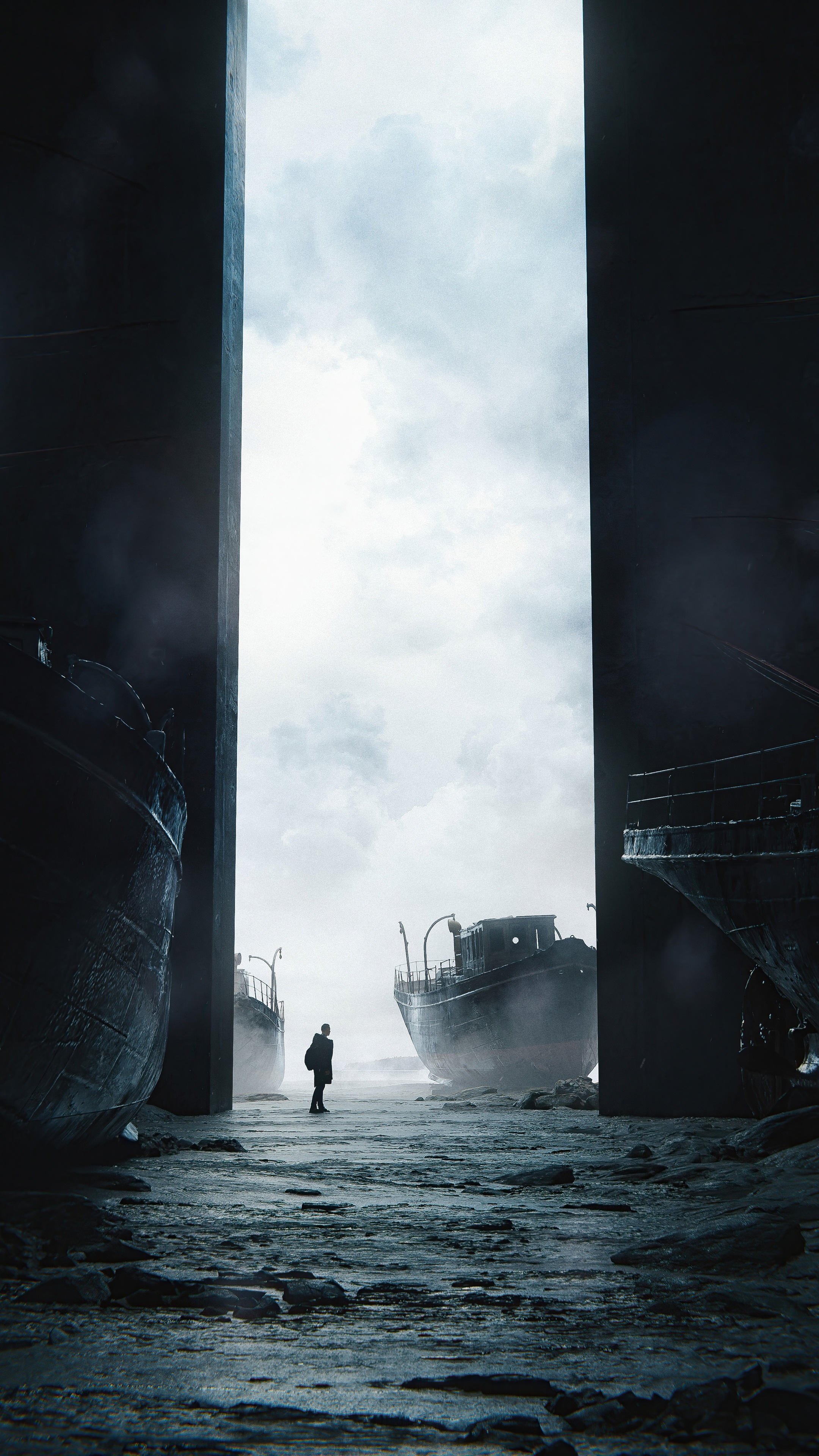 Man standing between derelict ships under cloudy sky HD Phone Wallpaper