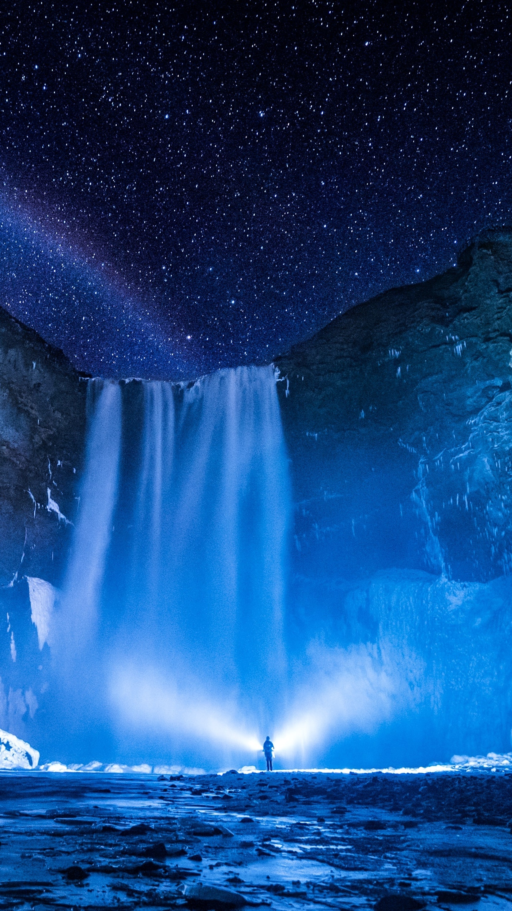 Waterfall under starry sky with person holding flashlight HD Phone Wallpaper
