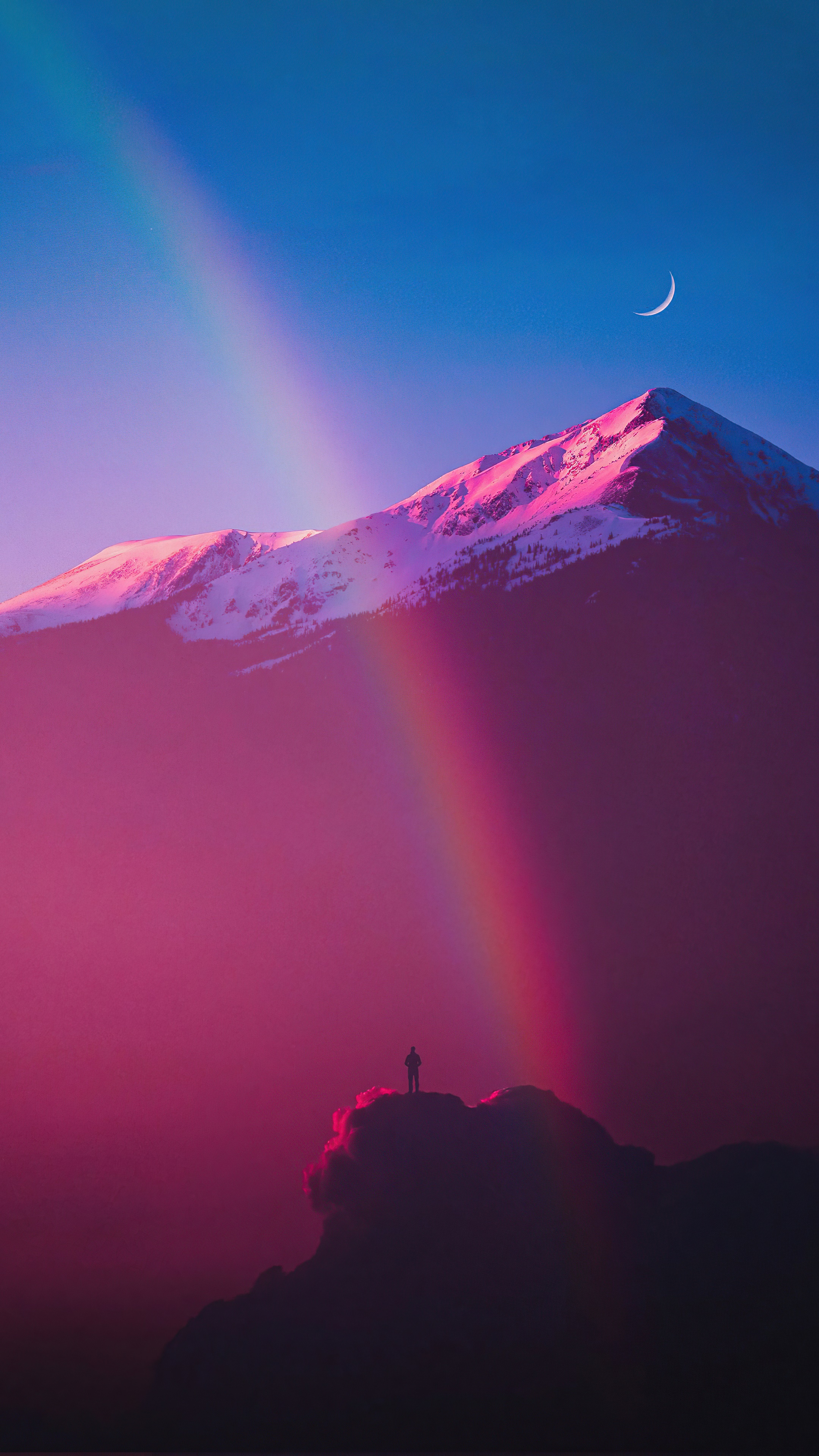Man on mountain peak with rainbow and moon HD Phone Wallpaper