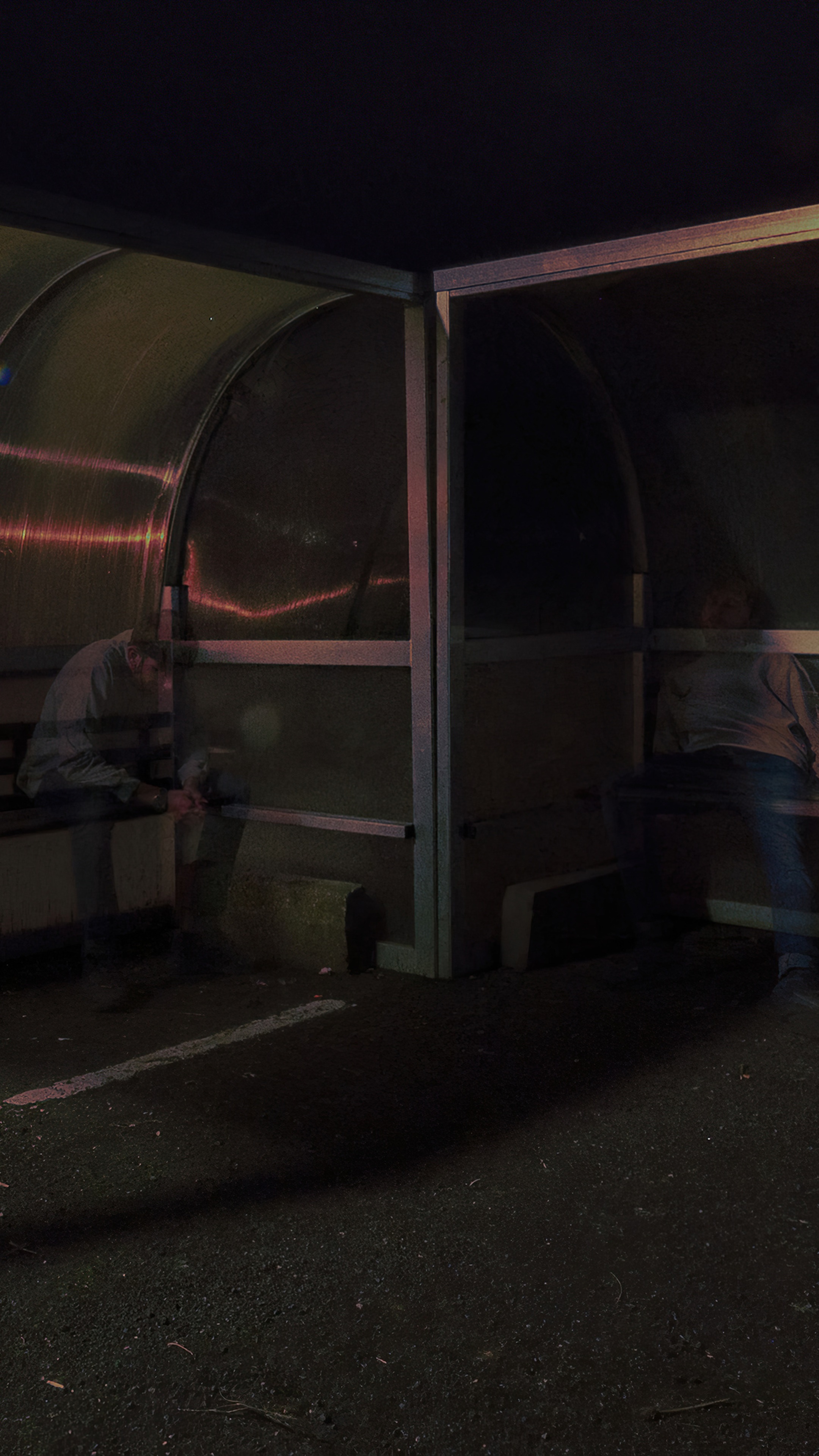 People sitting at a bus stop at night HD Phone Wallpaper