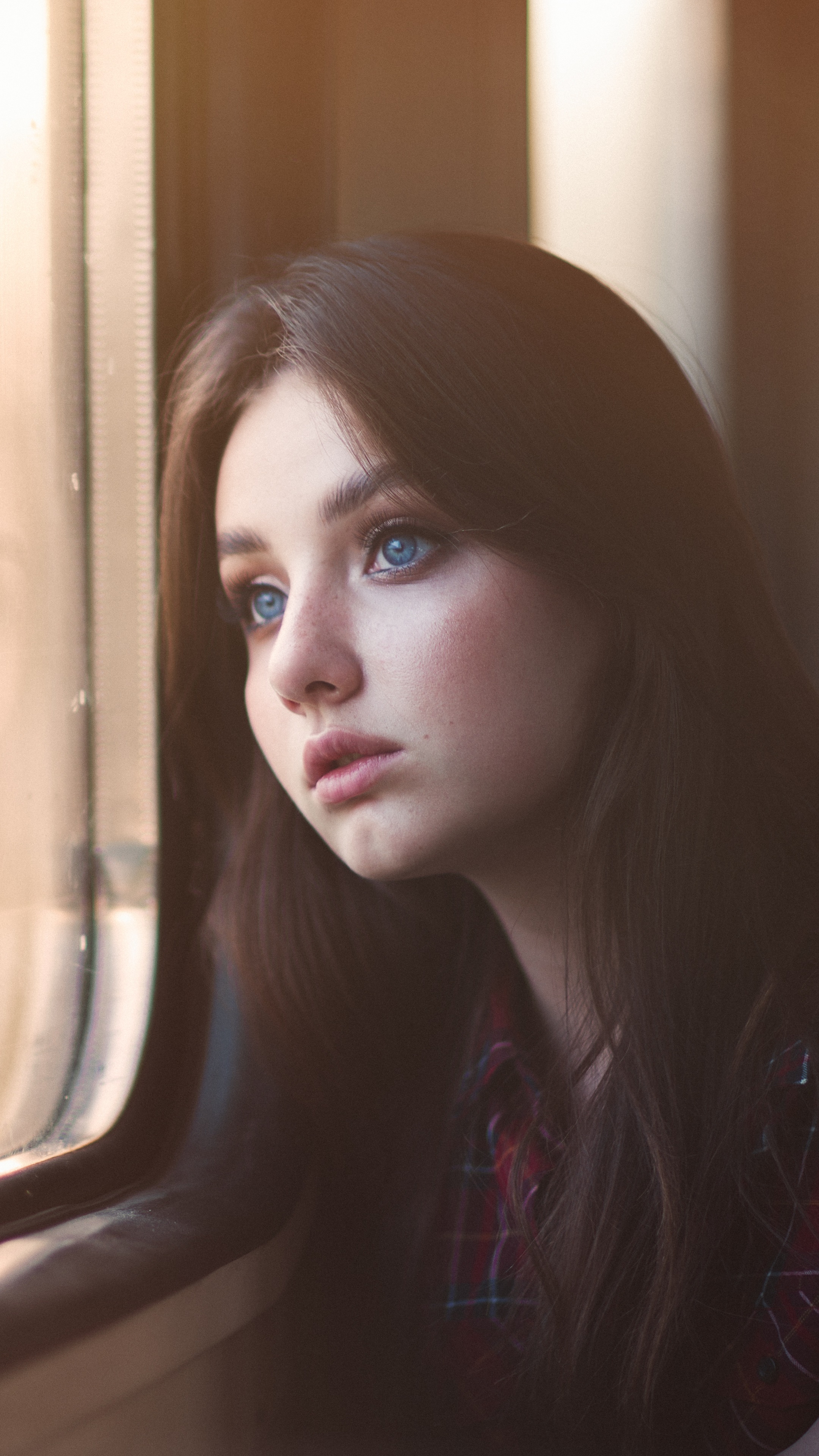 Girl with blue eyes looking out a train window HD Phone Wallpaper