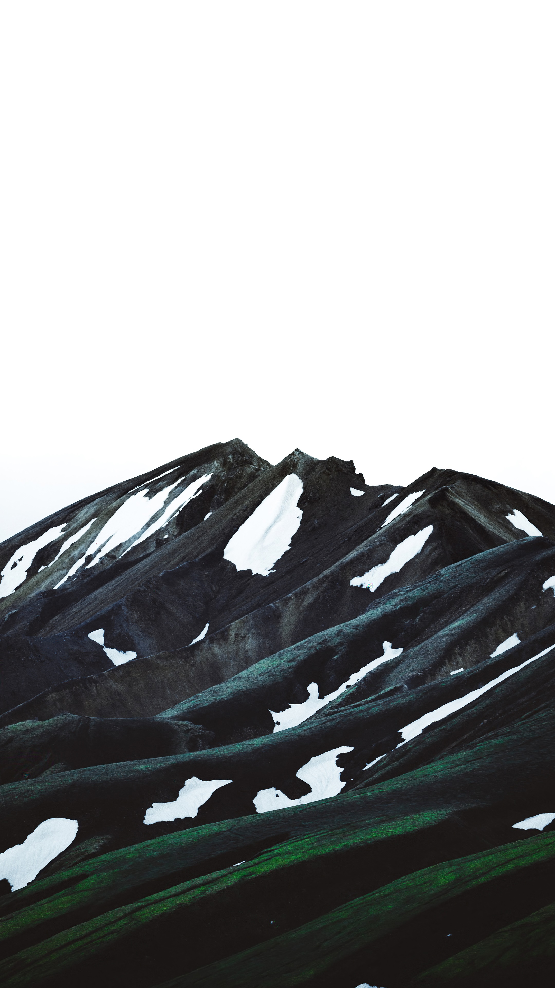 Mountain range with snow patches and green slopes HD Phone Wallpaper