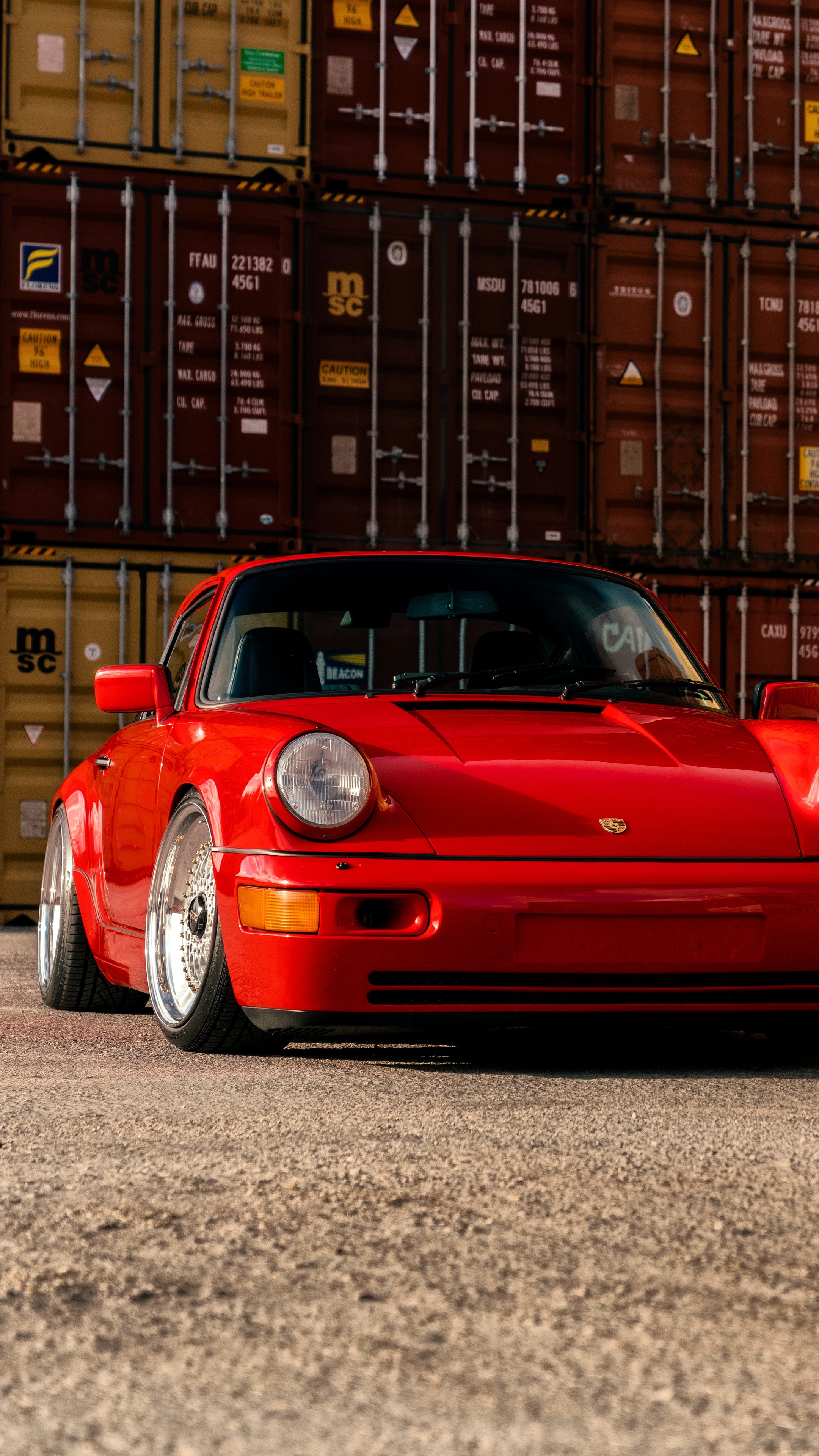 Red Porsche 911 parked in front of shipping containers HD Phone Wallpaper