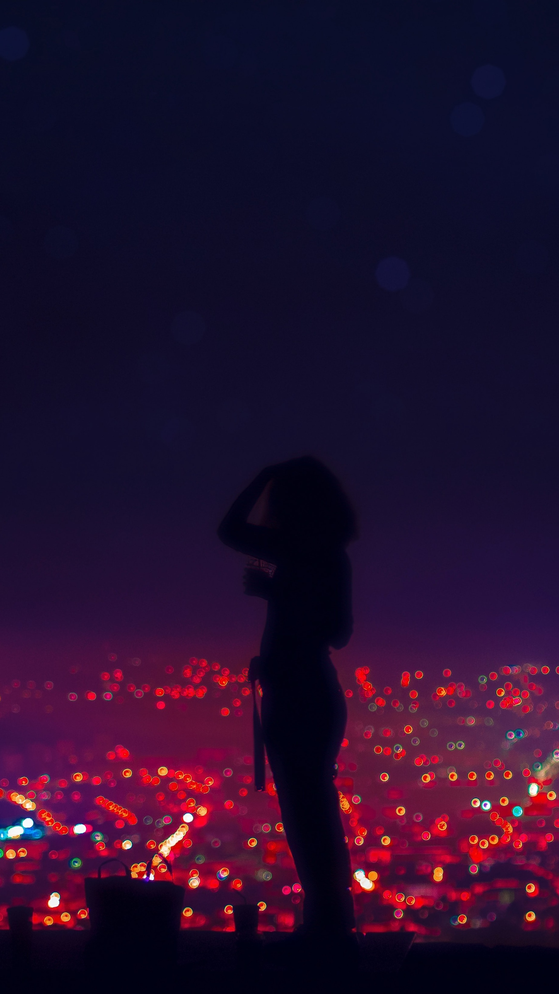 Silhouette of a person overlooking city lights at night HD Phone Wallpaper