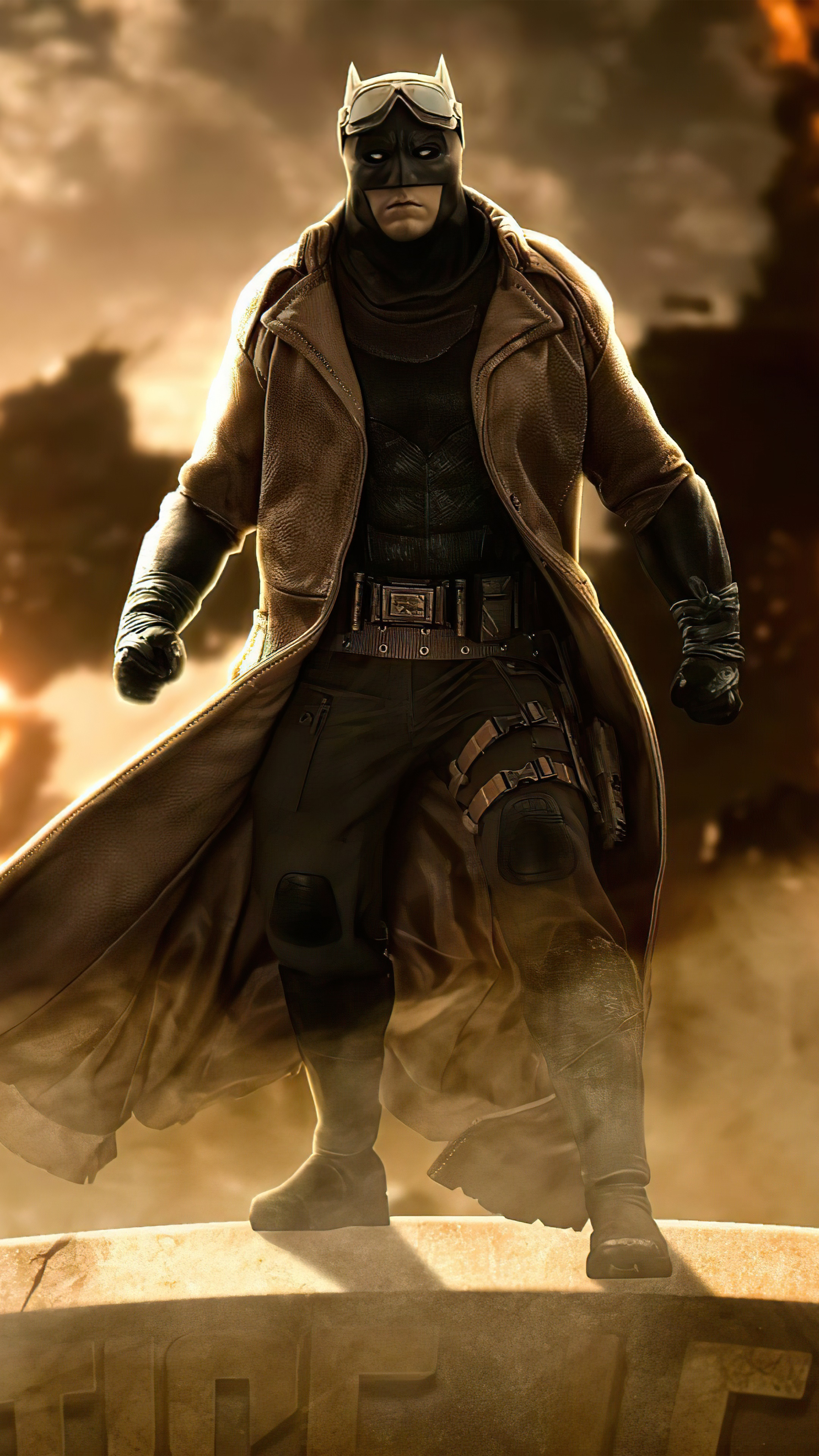 Batman in a brown trench coat and goggles HD Phone Wallpaper