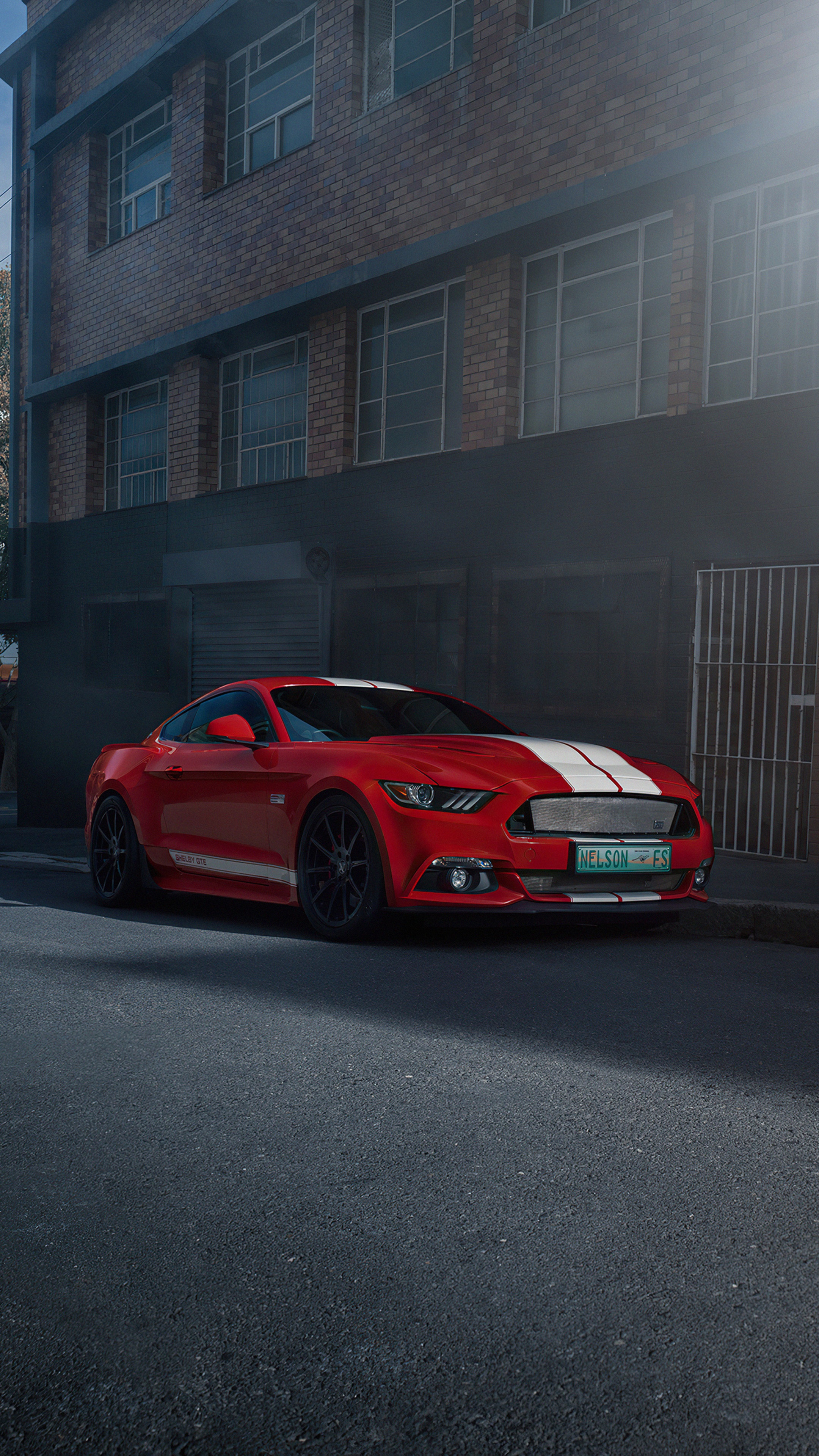Red Ford Mustang with white stripes parked on street HD Phone Wallpaper
