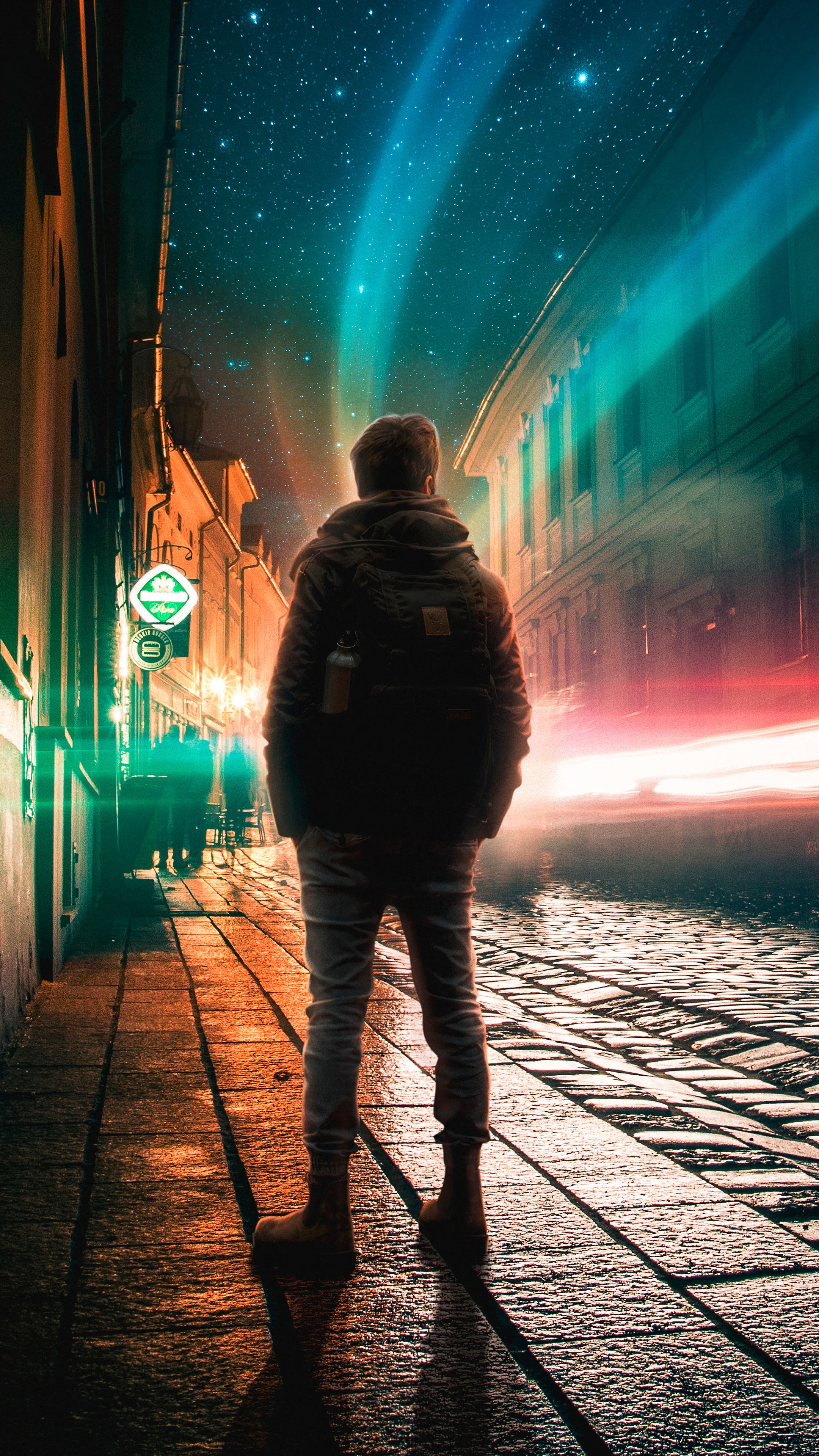 Man standing on cobblestone street at night with aurora HD Phone Wallpaper