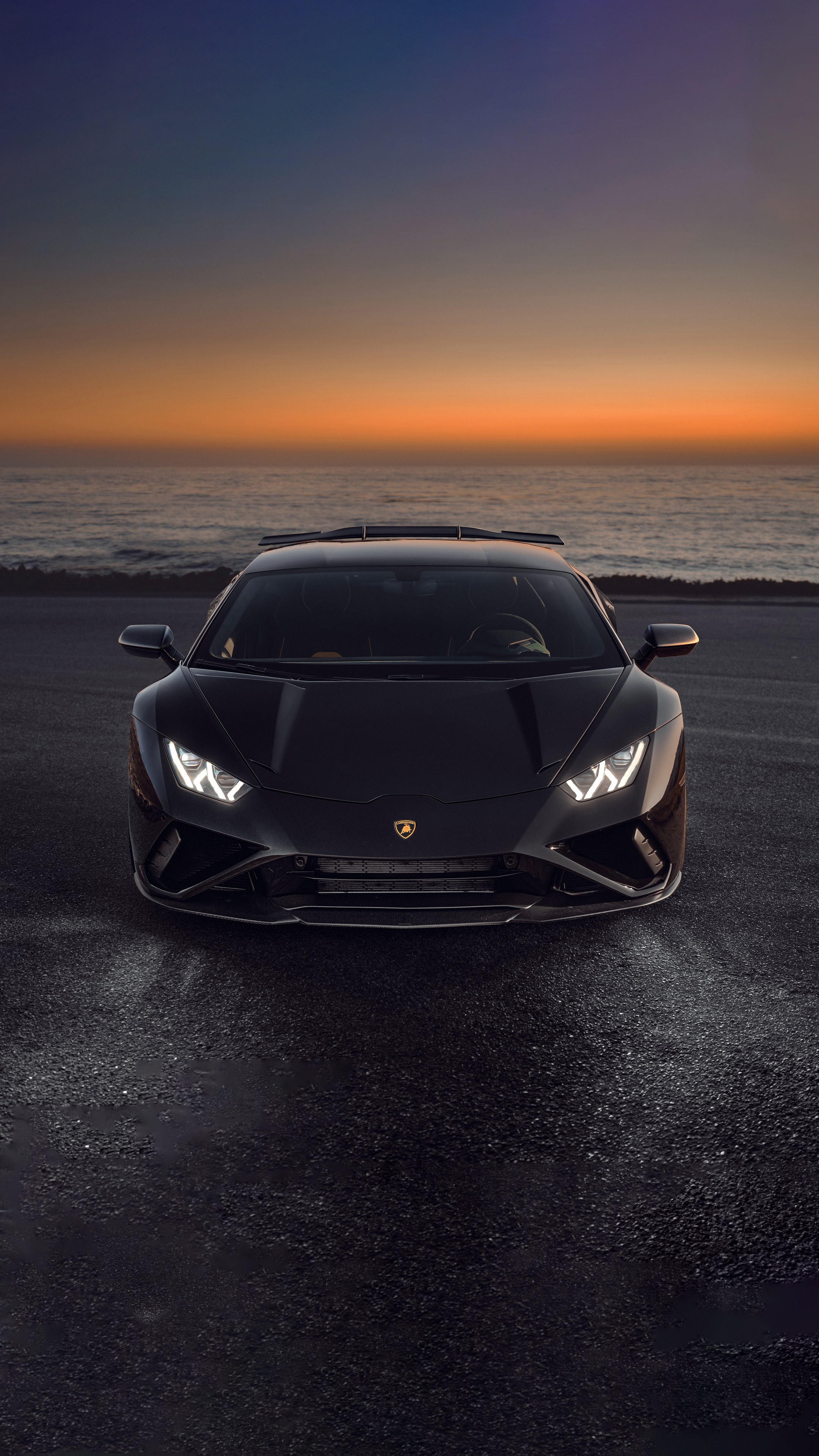 Black Lamborghini Huracan Evo on a road by the ocean at sunset HD Phone Wallpaper