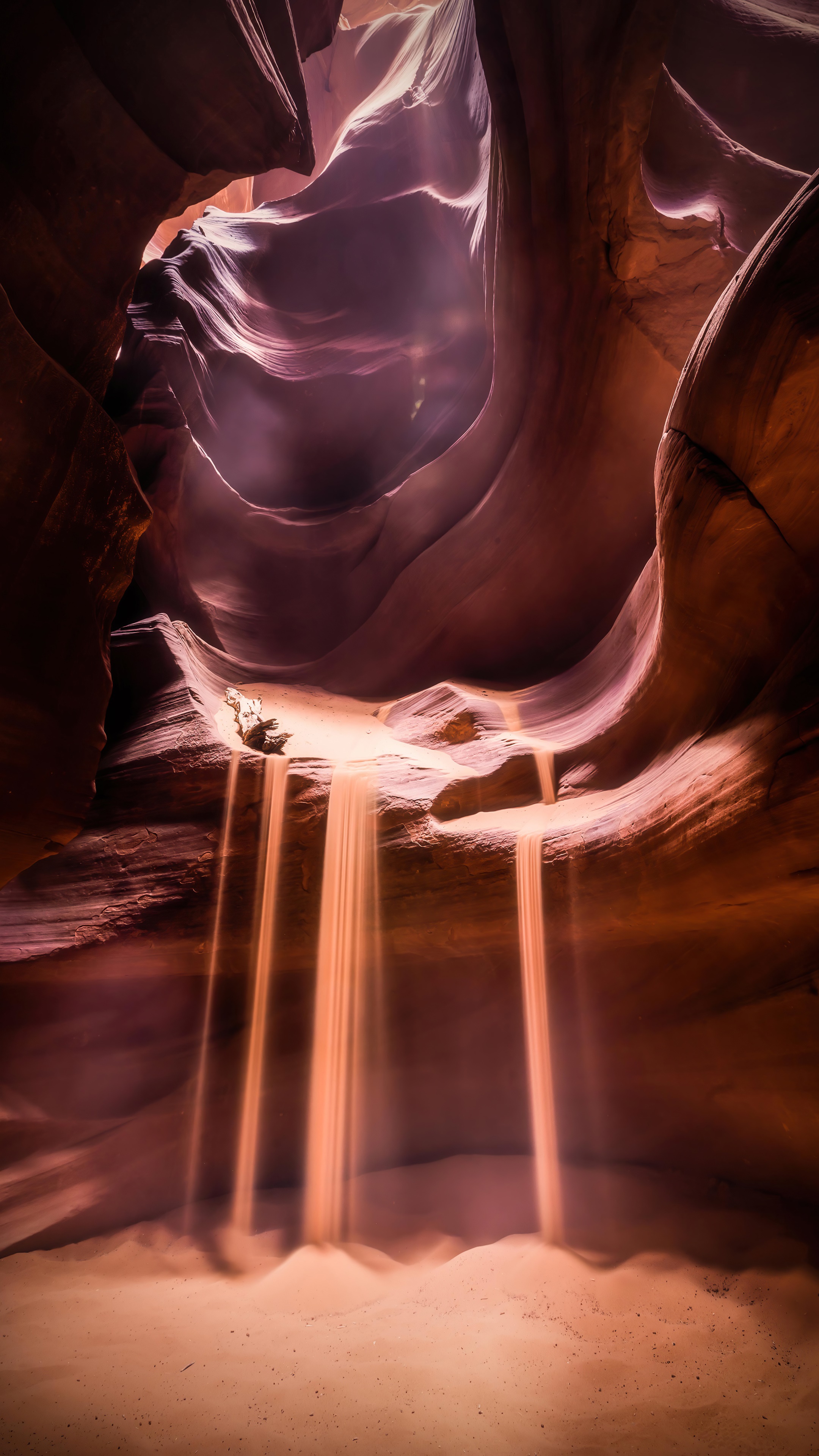 Sunbeams in a sandstone canyon with falling sand HD Phone Wallpaper