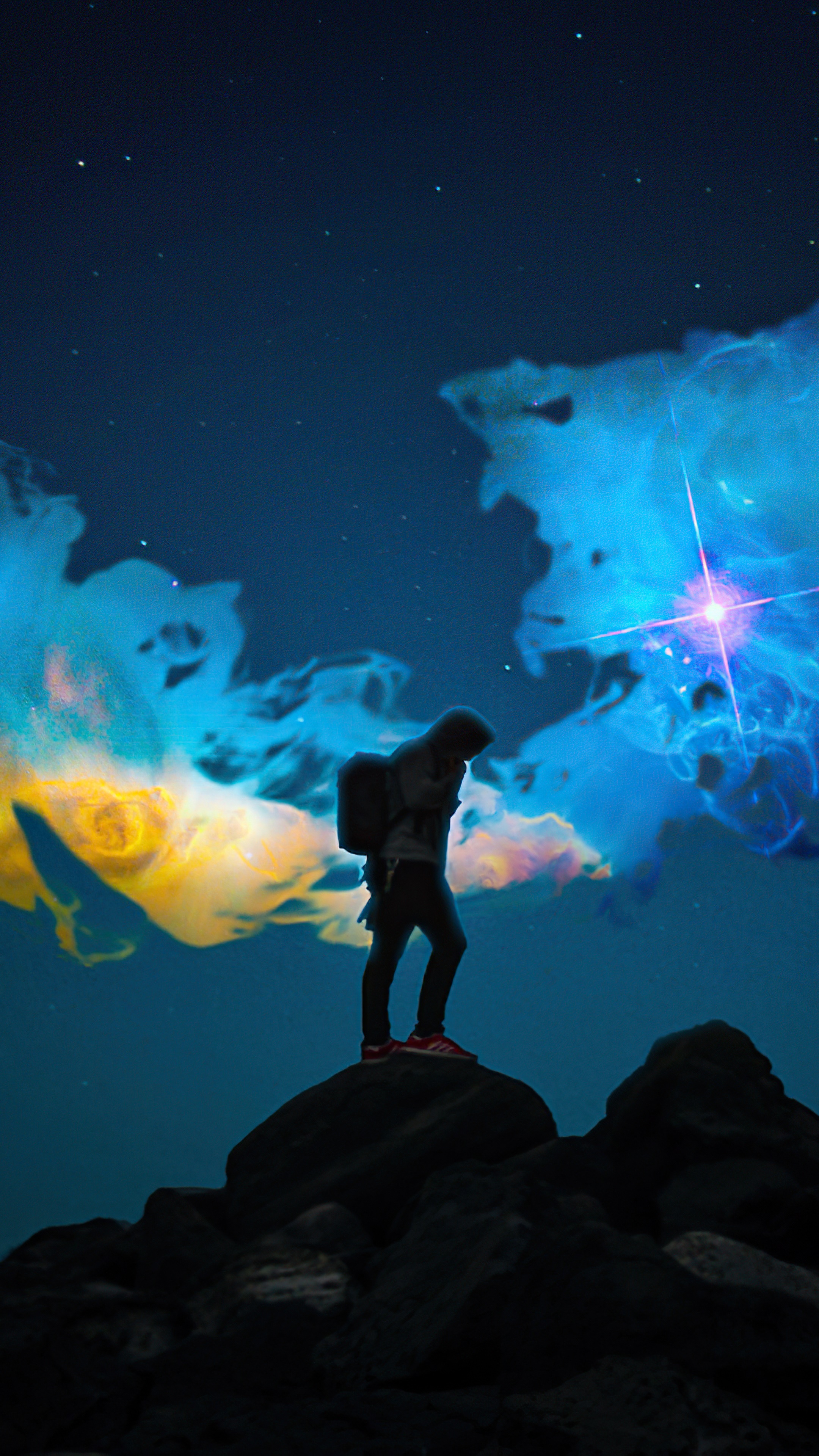 Silhouette of a person on rocks with nebula background HD Phone Wallpaper