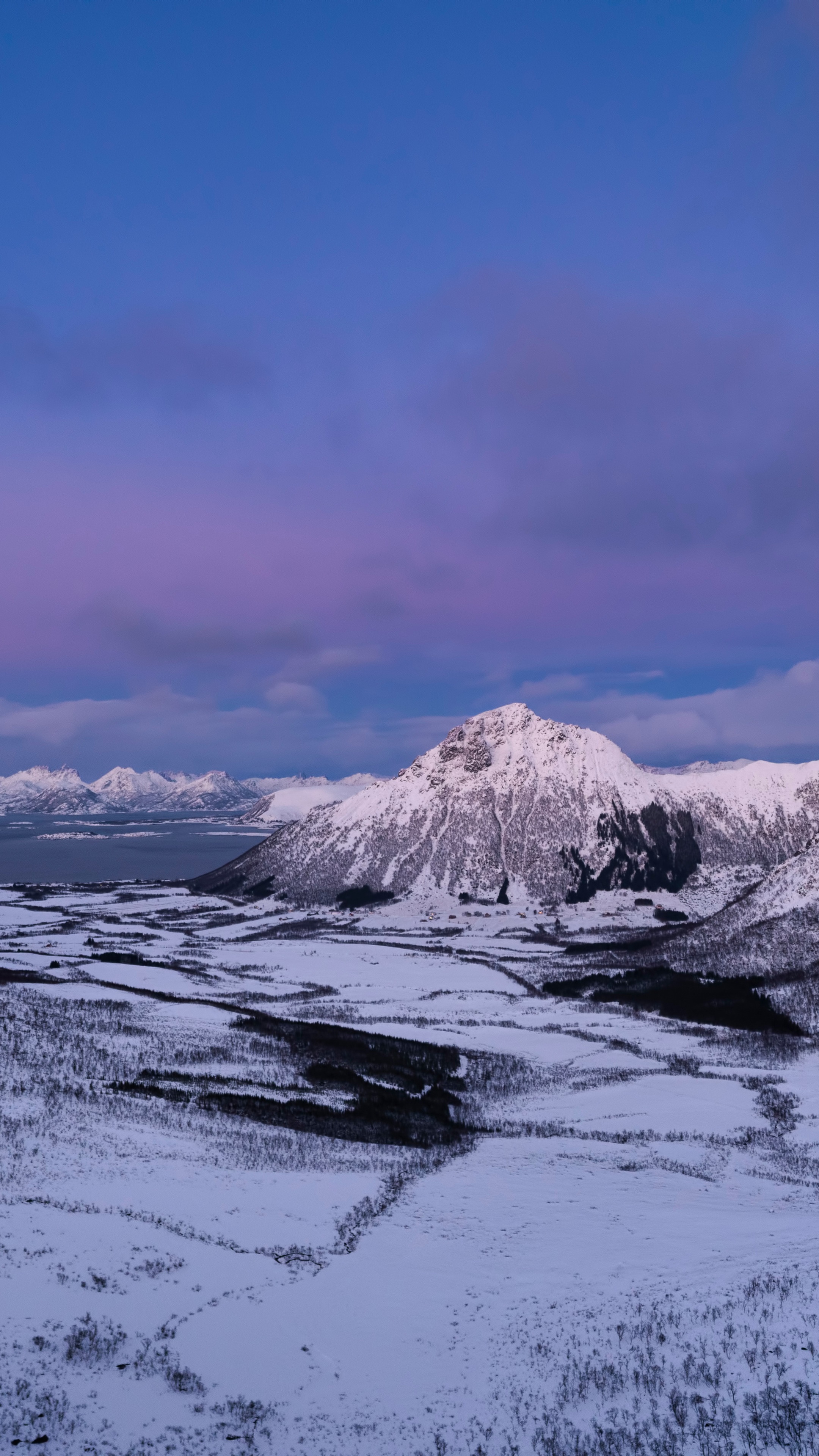 Snow-covered mountains and landscape under a purple sky HD Phone Wallpaper