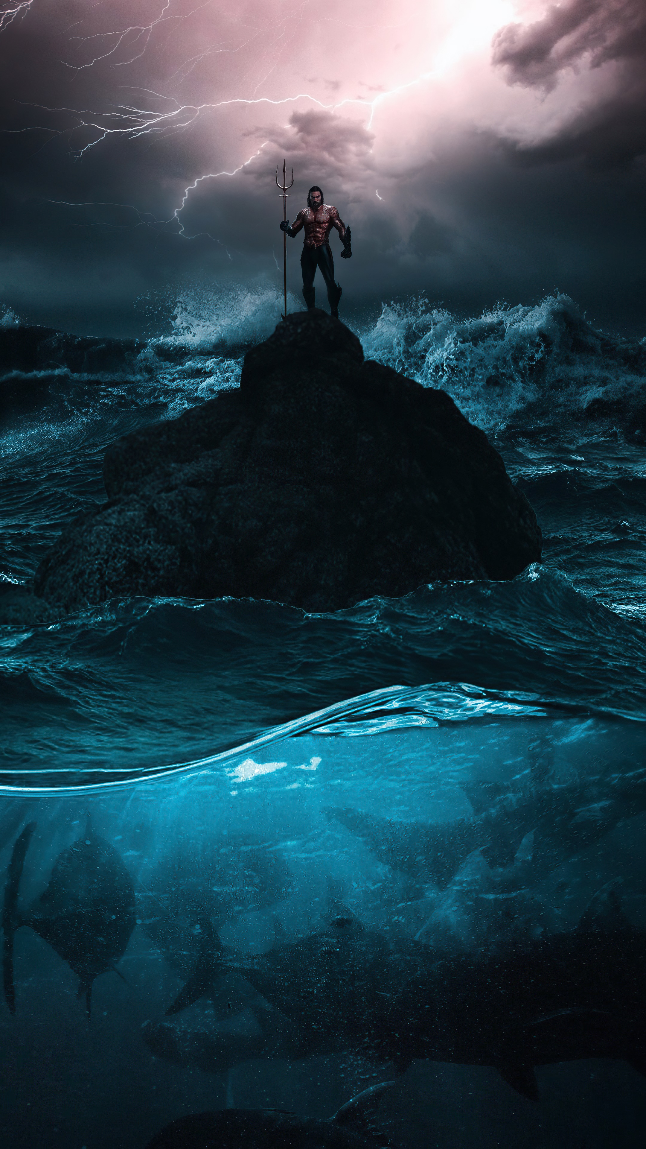 Aquaman standing on a rock in the ocean with sharks below HD Phone Wallpaper