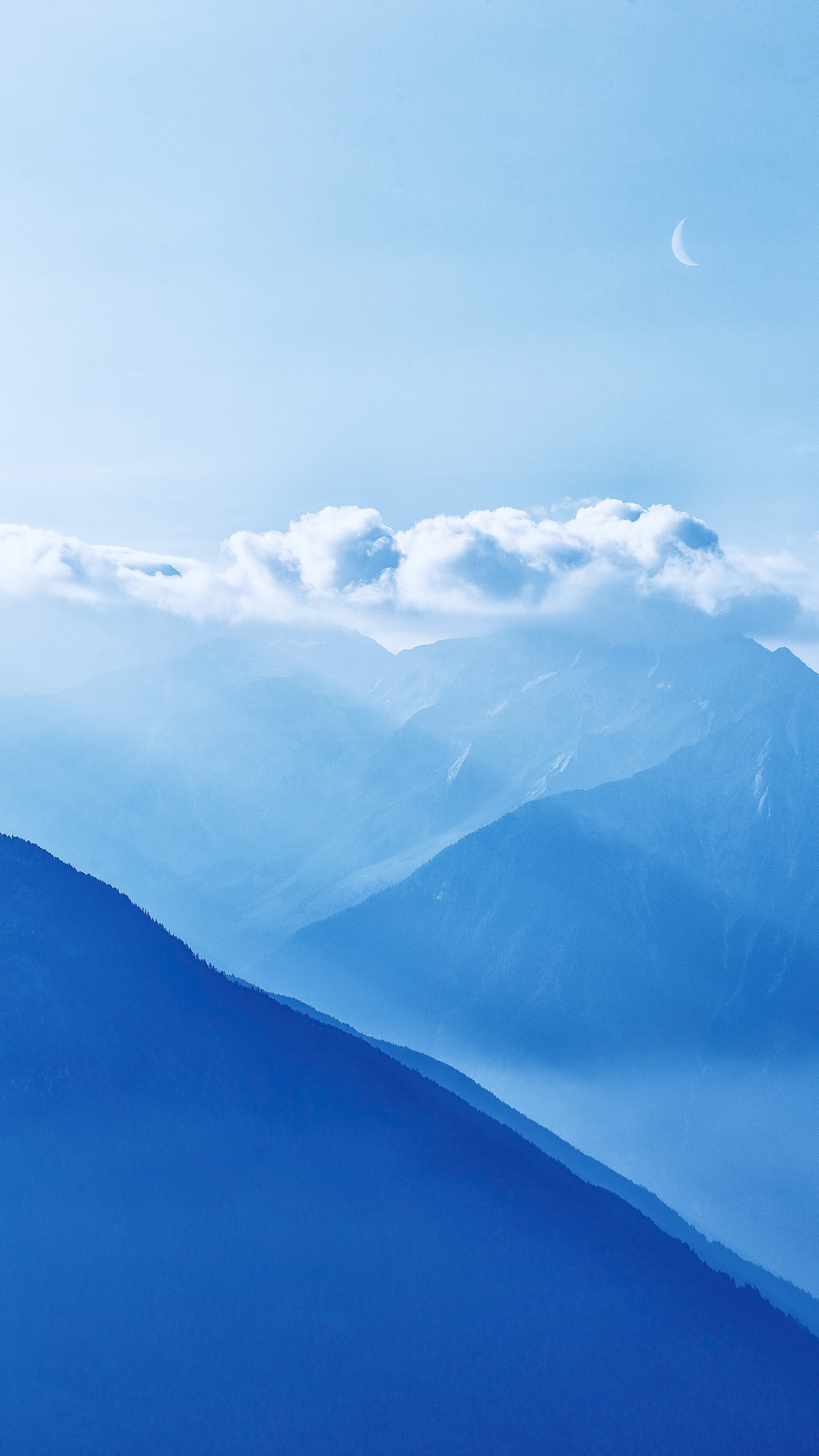 Mountains and clouds with a crescent moon in the sky HD Phone Wallpaper