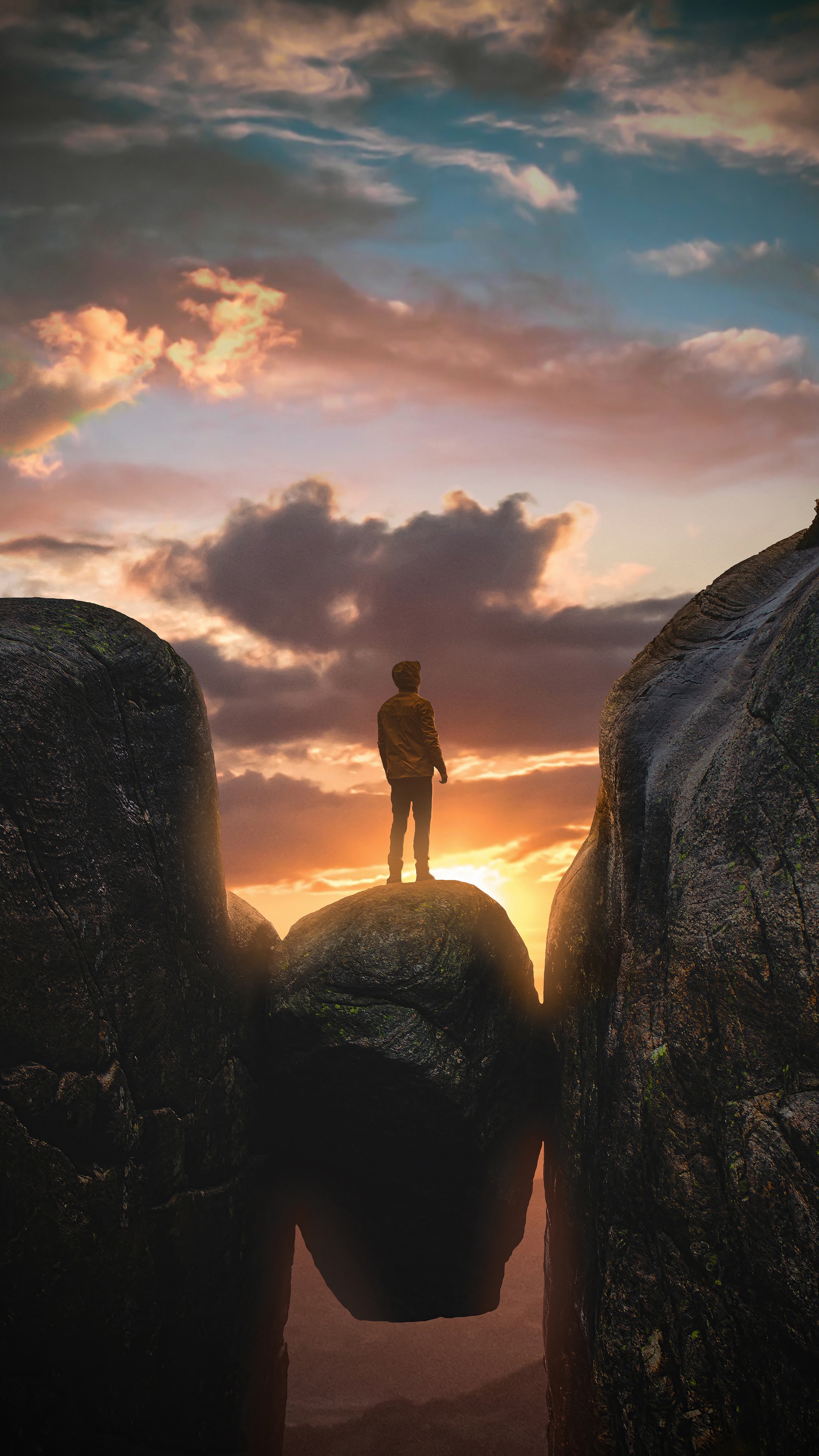 Man standing on a rock between mountains at sunset HD Phone Wallpaper