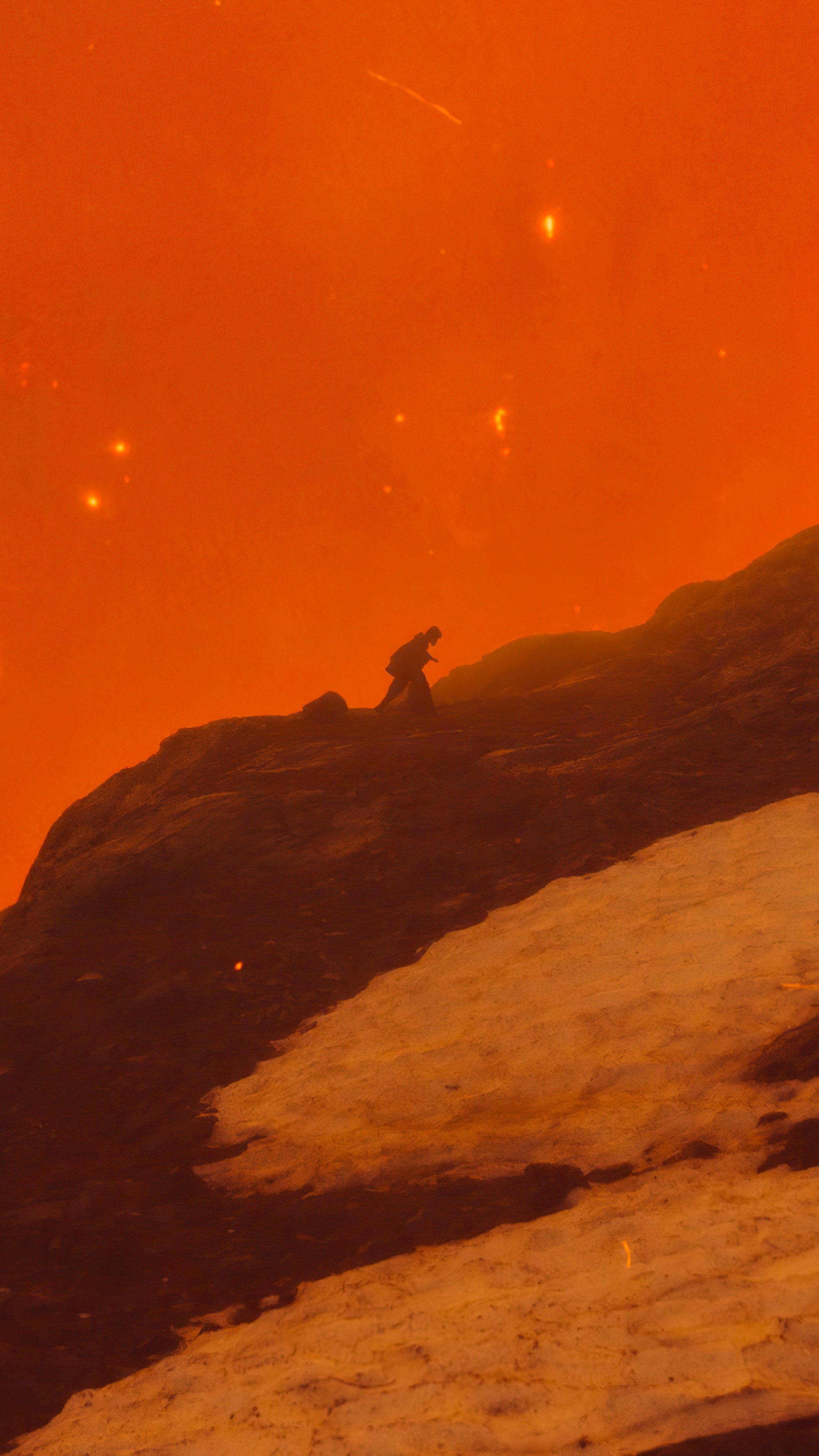 Person climbing a rocky, snowy mountain under an orange sky HD Phone Wallpaper