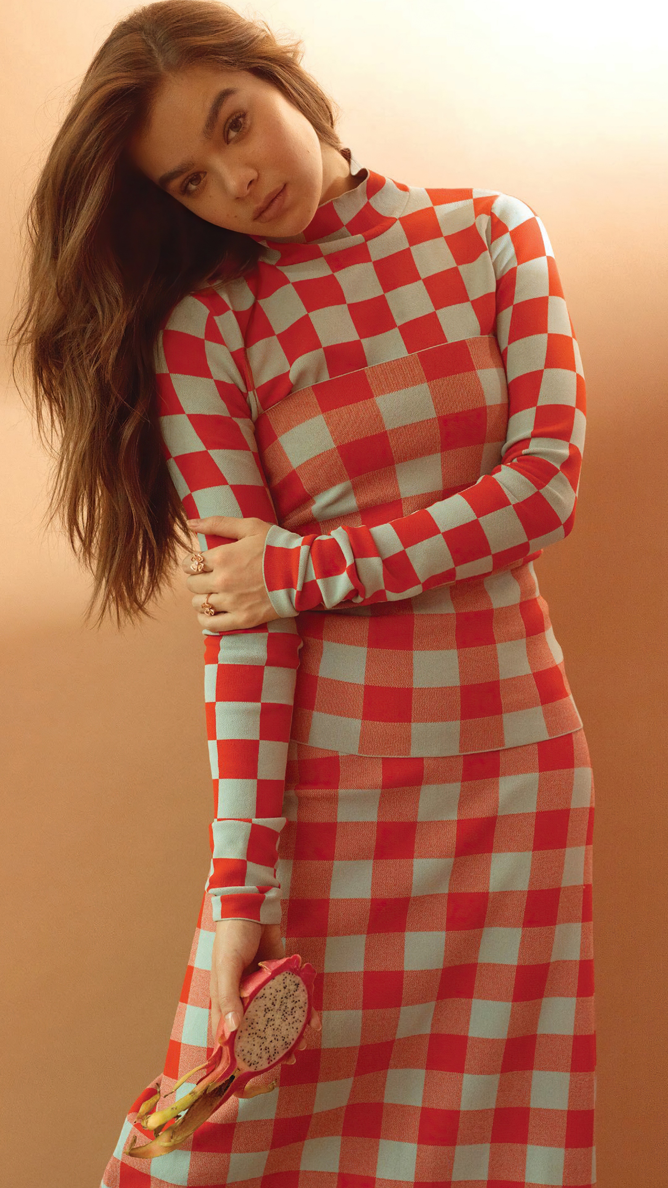 Hailee Steinfeld in checkered outfit holding dragon fruit HD Phone Wallpaper