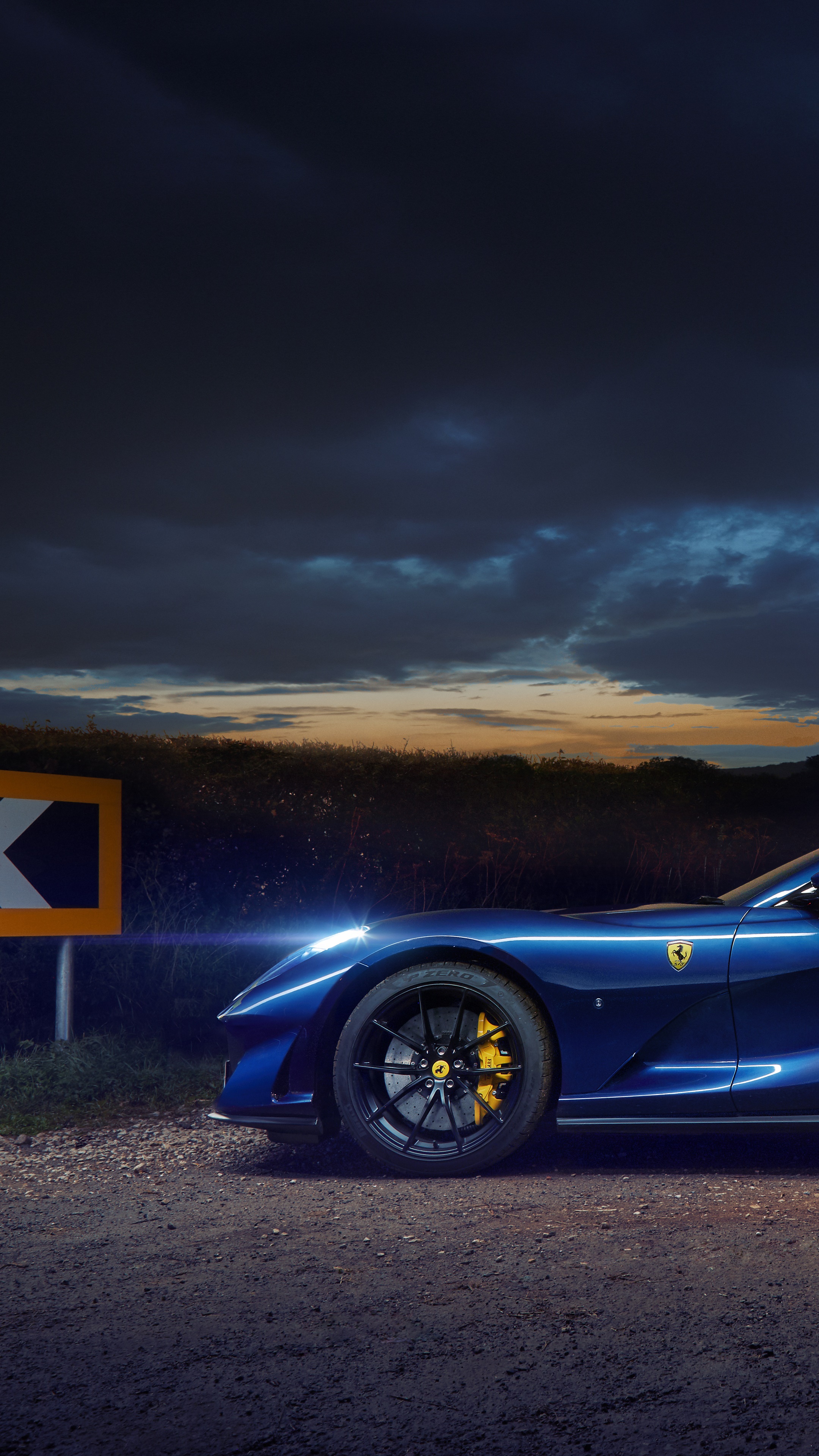 Blue Ferrari 812 parked on a dirt road at dusk HD Phone Wallpaper