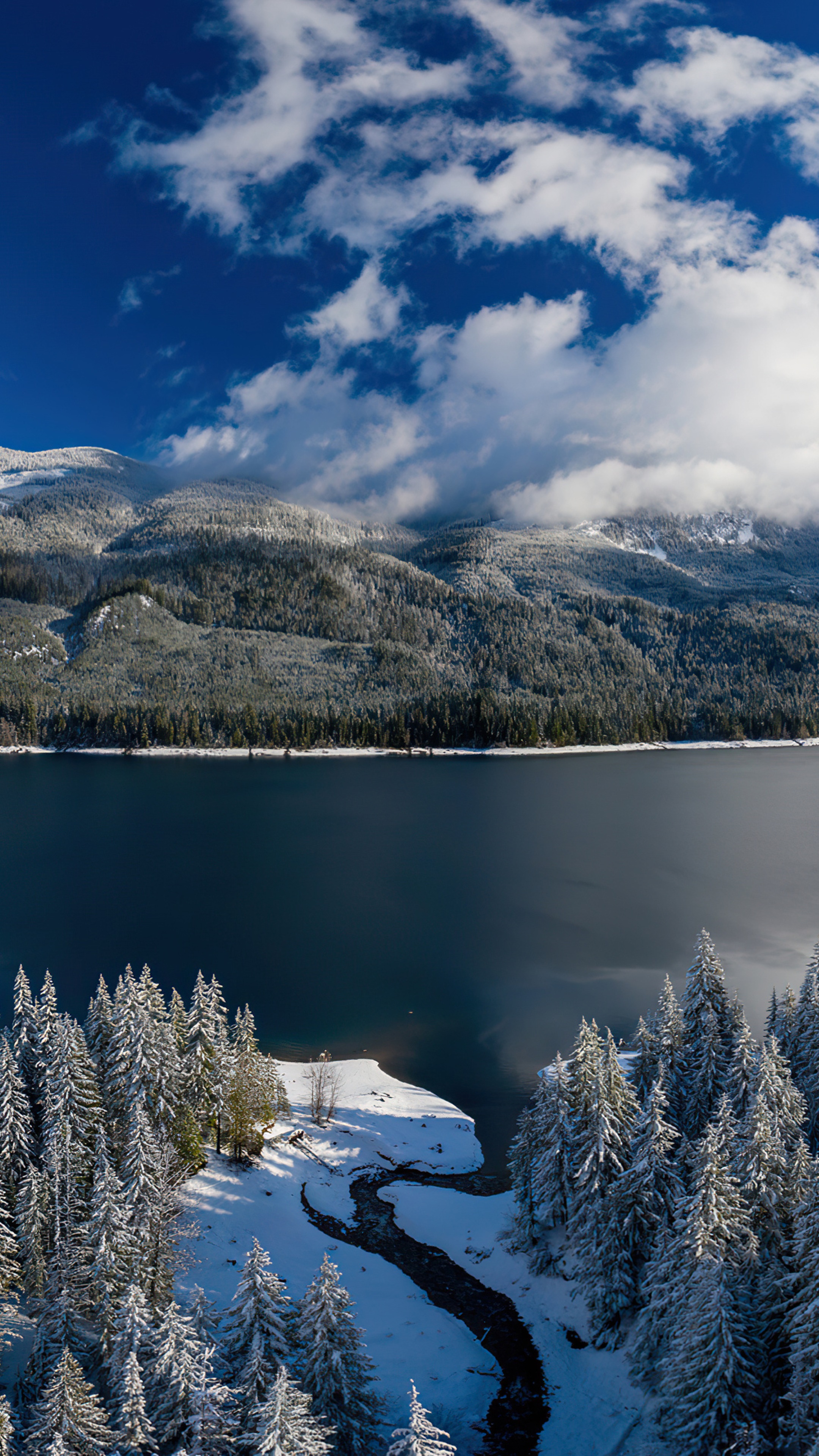 Snow-covered mountains and lake under a cloudy sky HD Phone Wallpaper