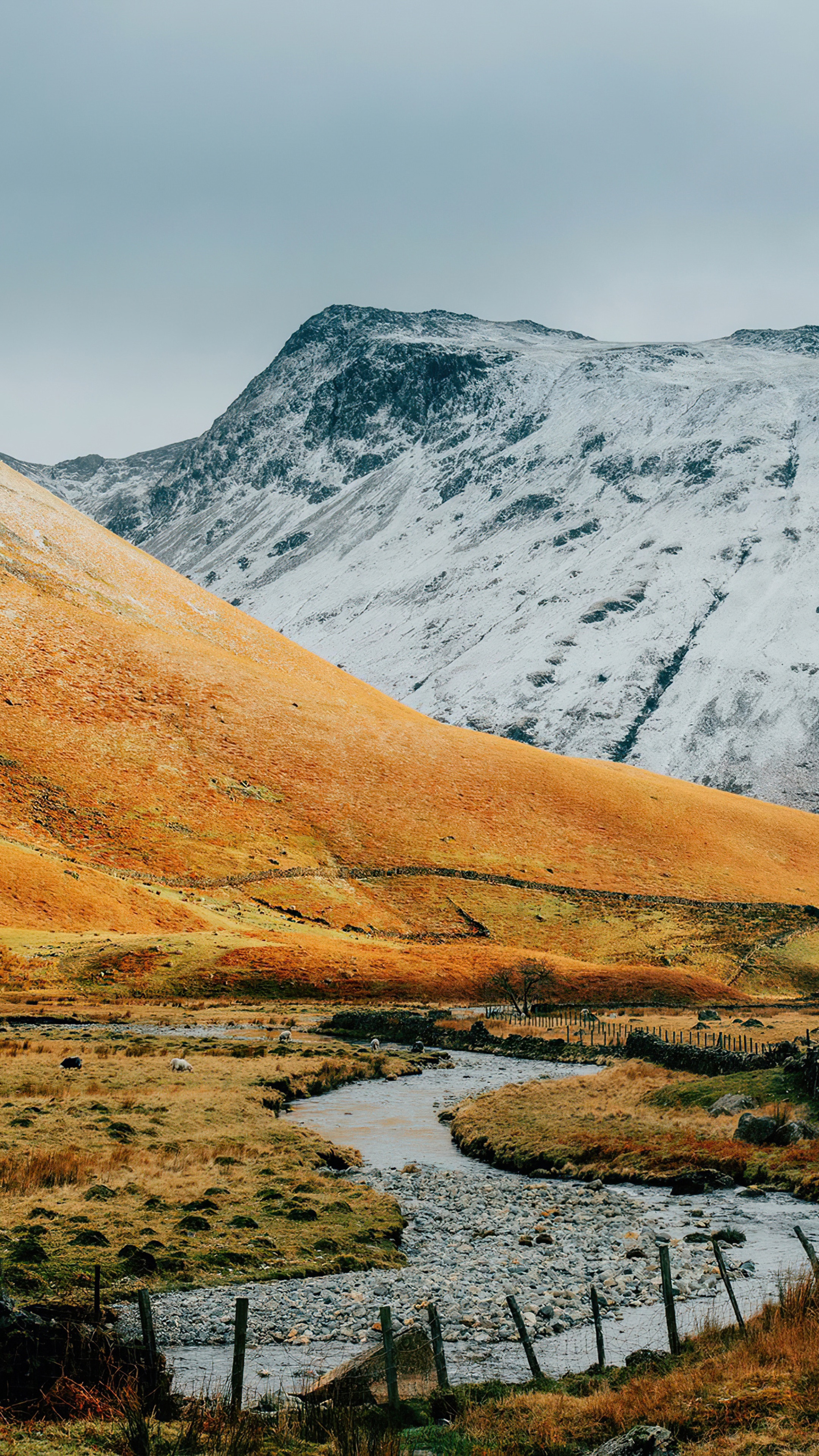 Snow-capped mountains and a winding stream in a valley HD Phone Wallpaper