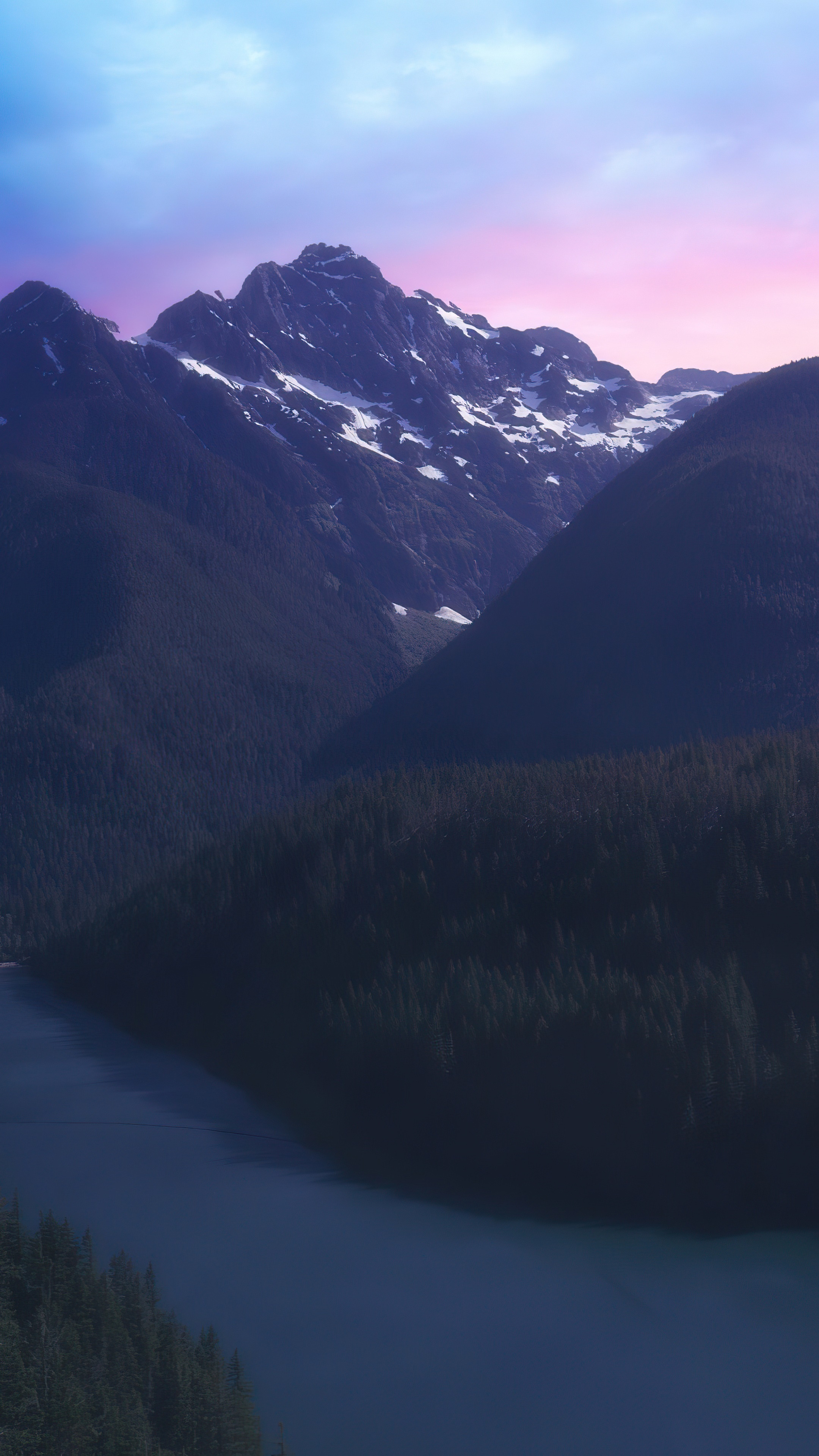 Snow-capped mountains over a dark forest and lake HD Phone Wallpaper