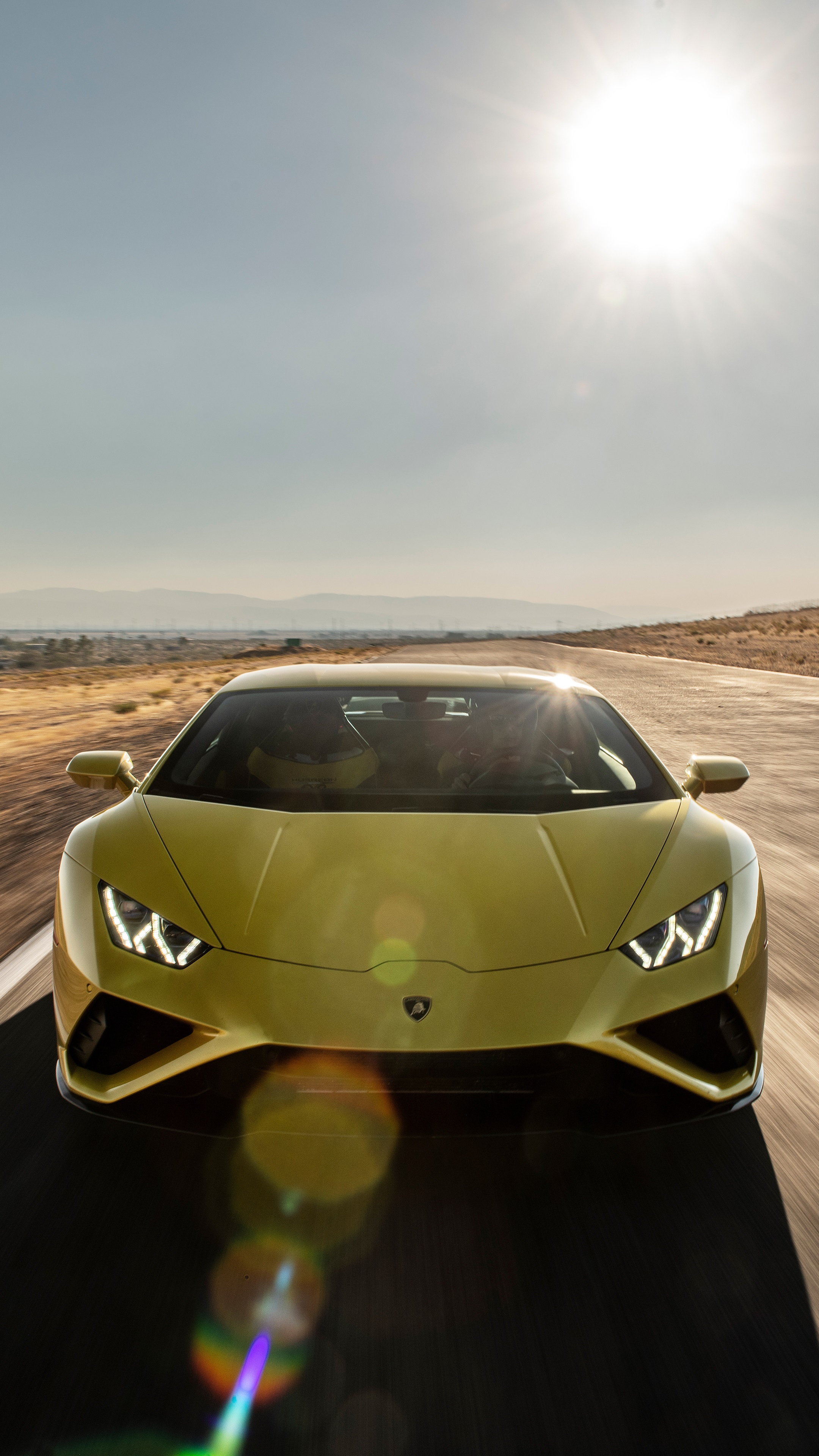 Yellow Lamborghini Huracan driving on a road HD Phone Wallpaper