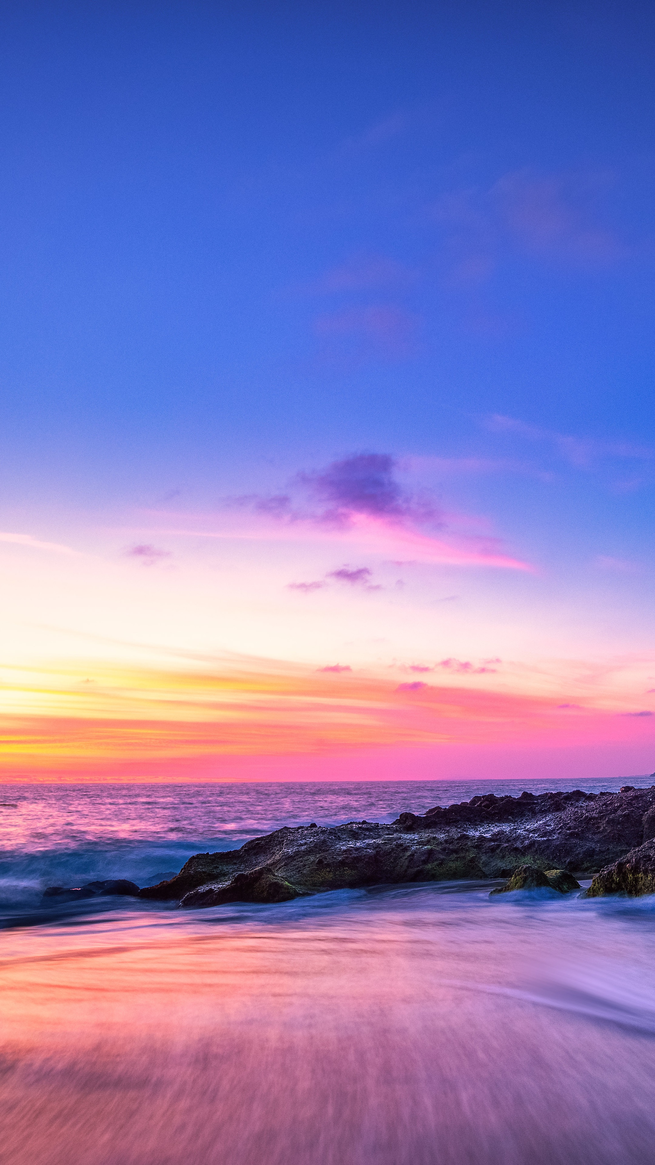 Long exposure seascape at sunset with rocky shore HD Phone Wallpaper