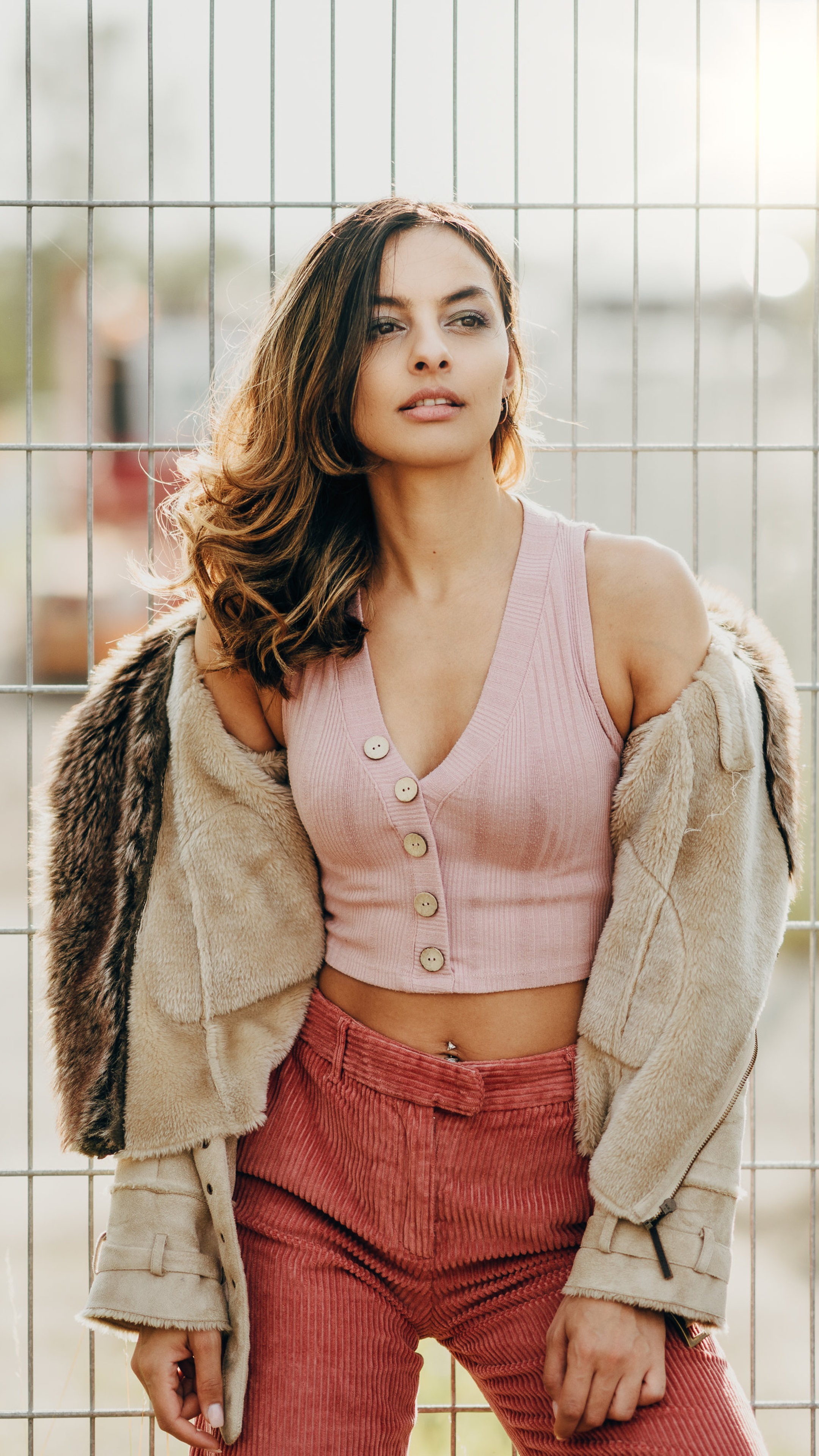 Model wearing pink crop top and corduroy pants HD Phone Wallpaper