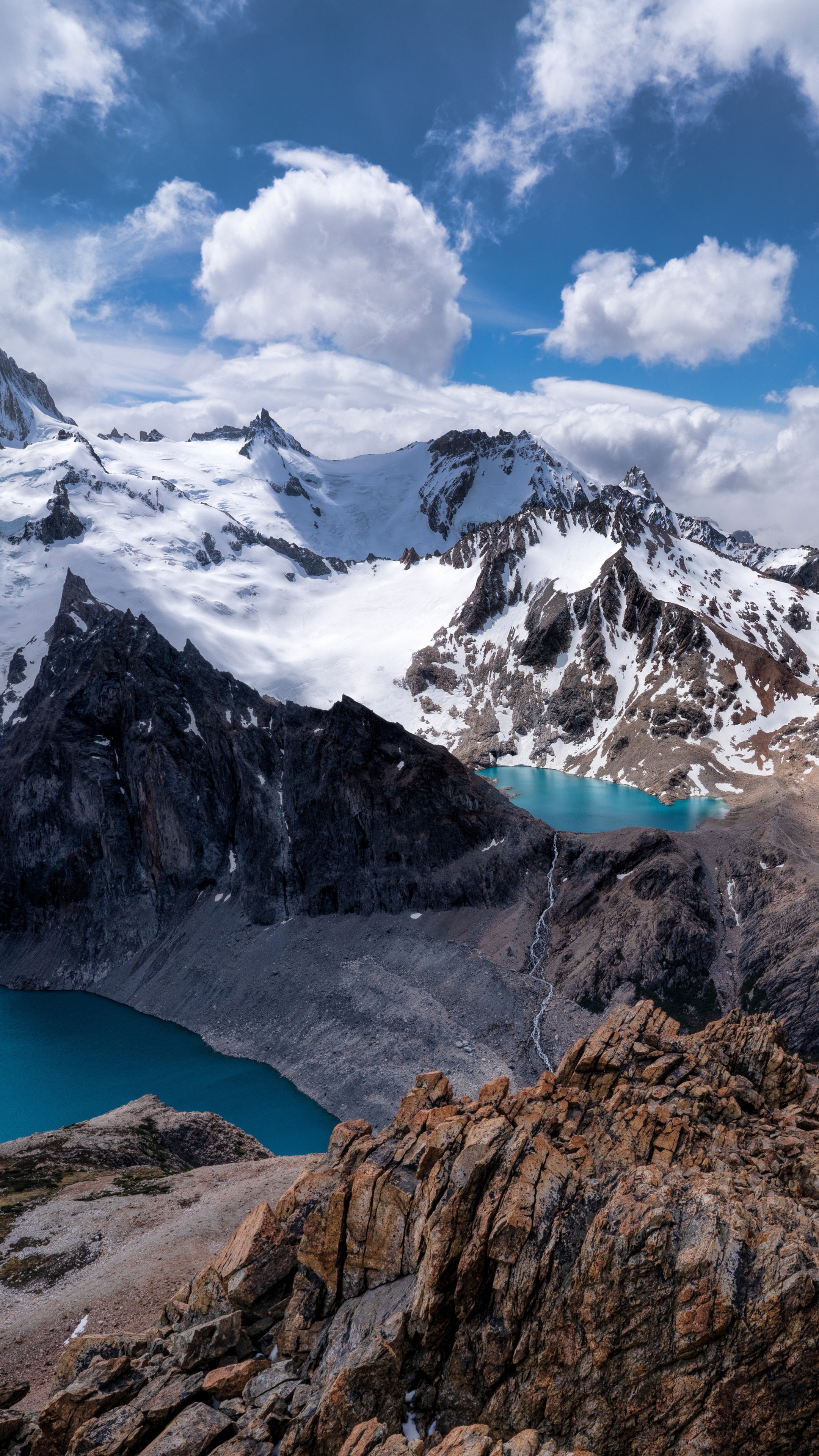 Snow-capped mountains and turquoise lakes under a cloudy sky HD Phone Wallpaper