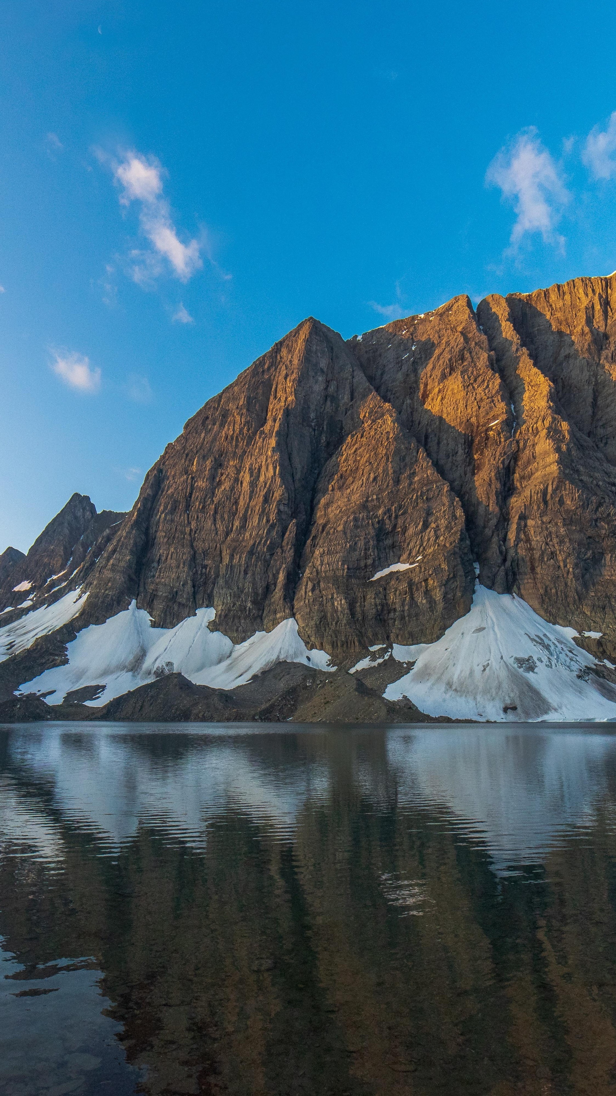 Lake reflecting mountains under a blue sky HD Phone Wallpaper