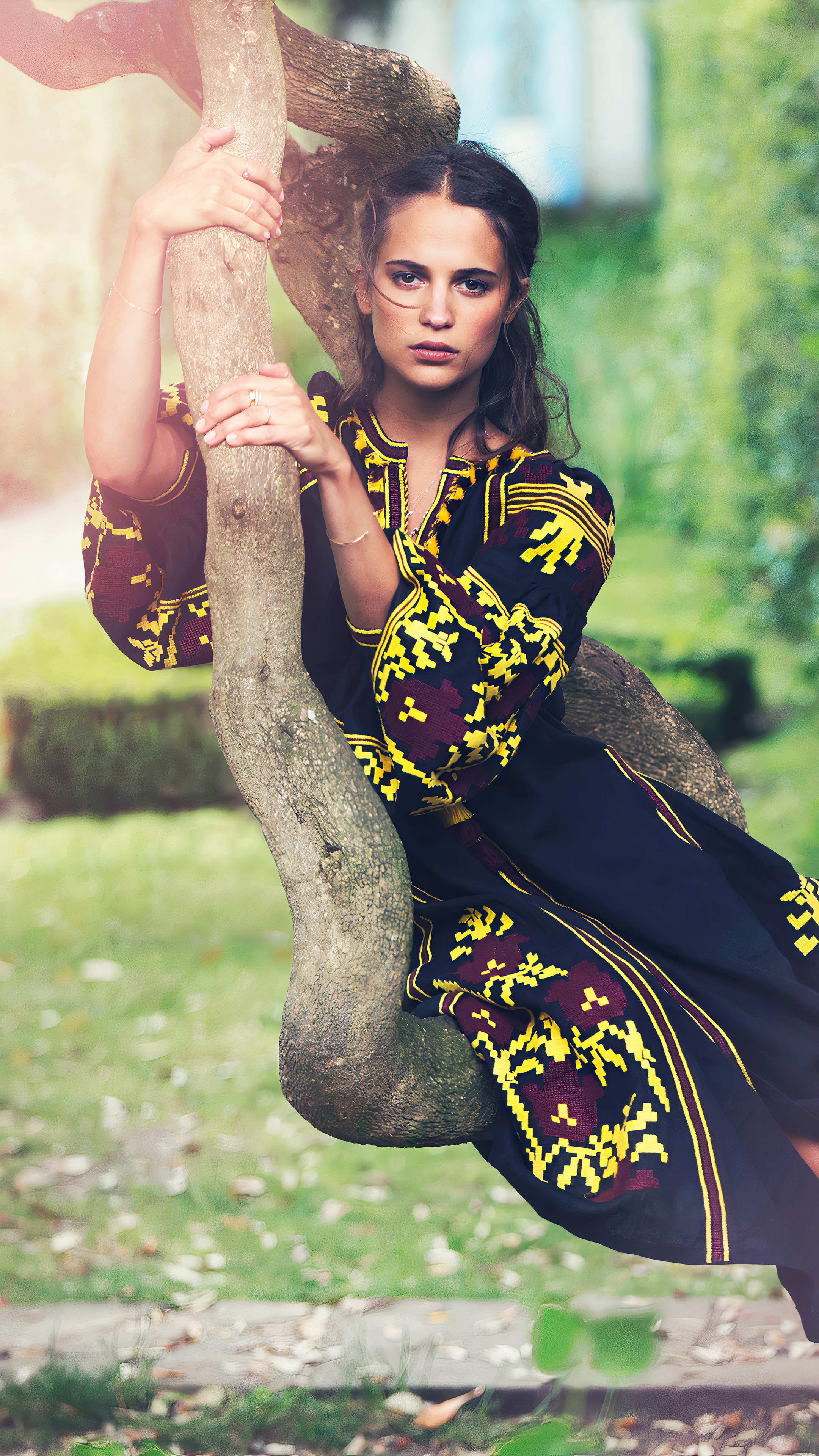 Alicia Vikander sitting on a tree branch HD Phone Wallpaper