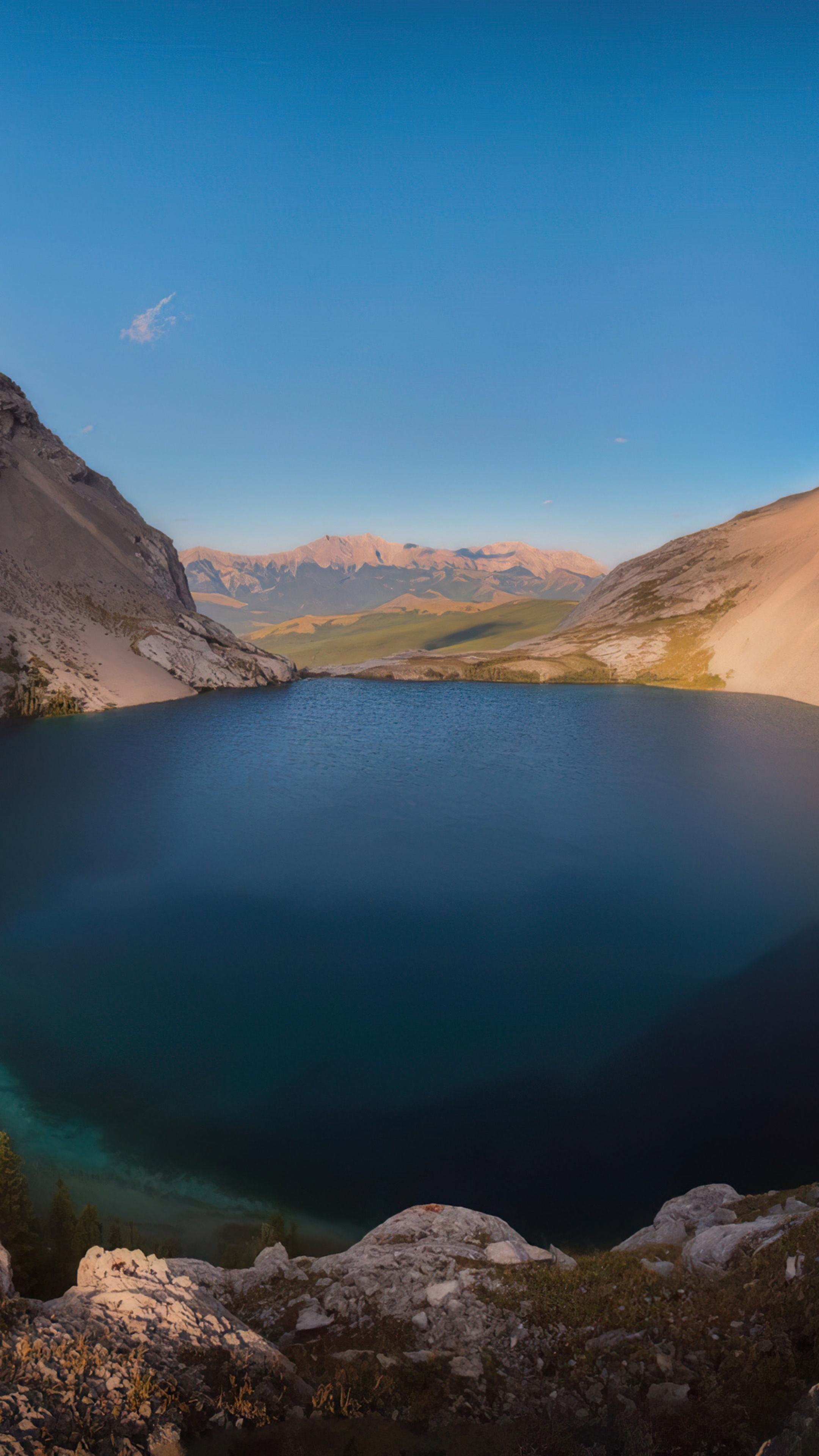 Lake surrounded by mountains and rocky shore HD Phone Wallpaper