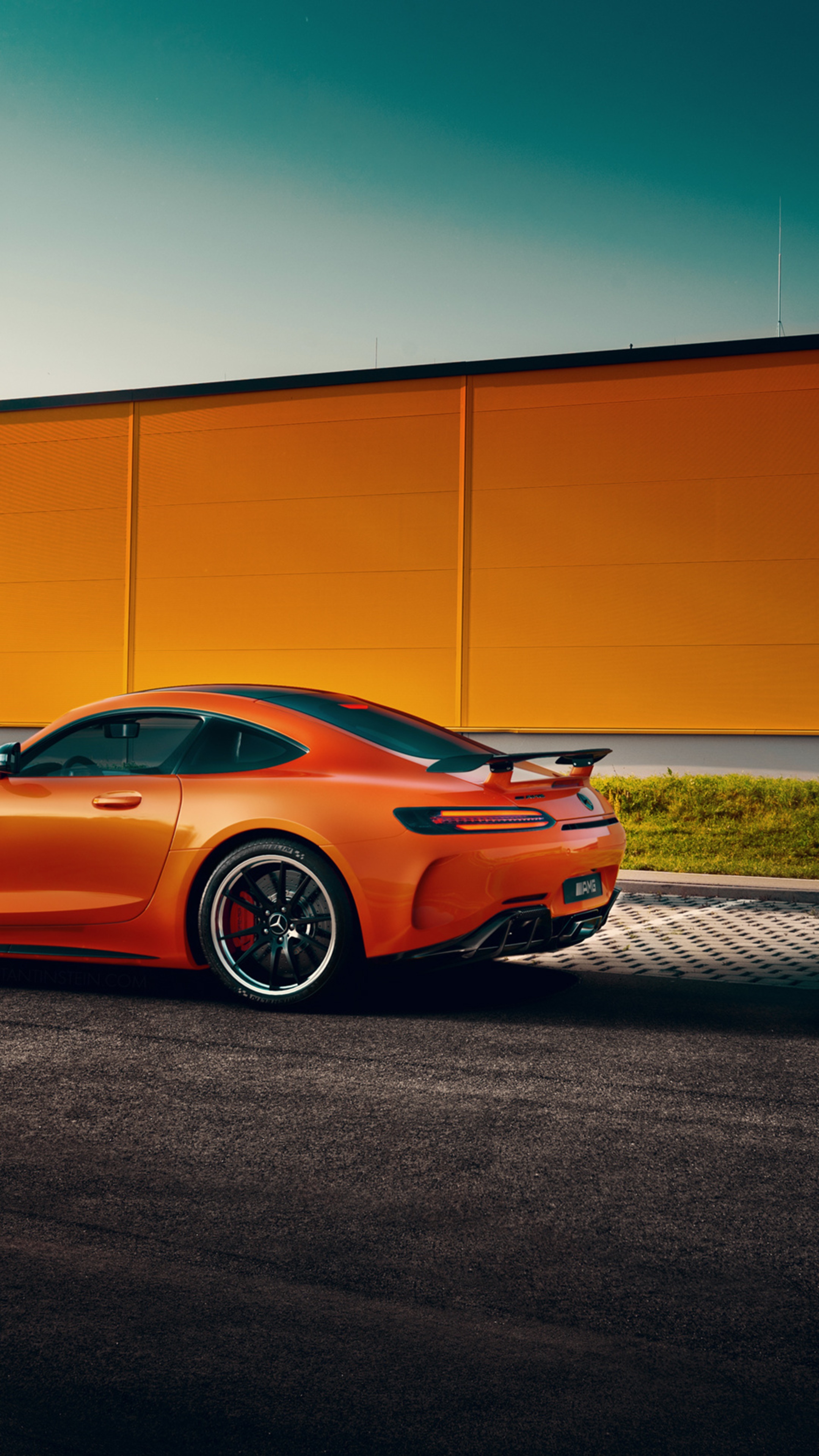 Orange Mercedes-AMG GT parked in front of an orange wall HD Phone Wallpaper
