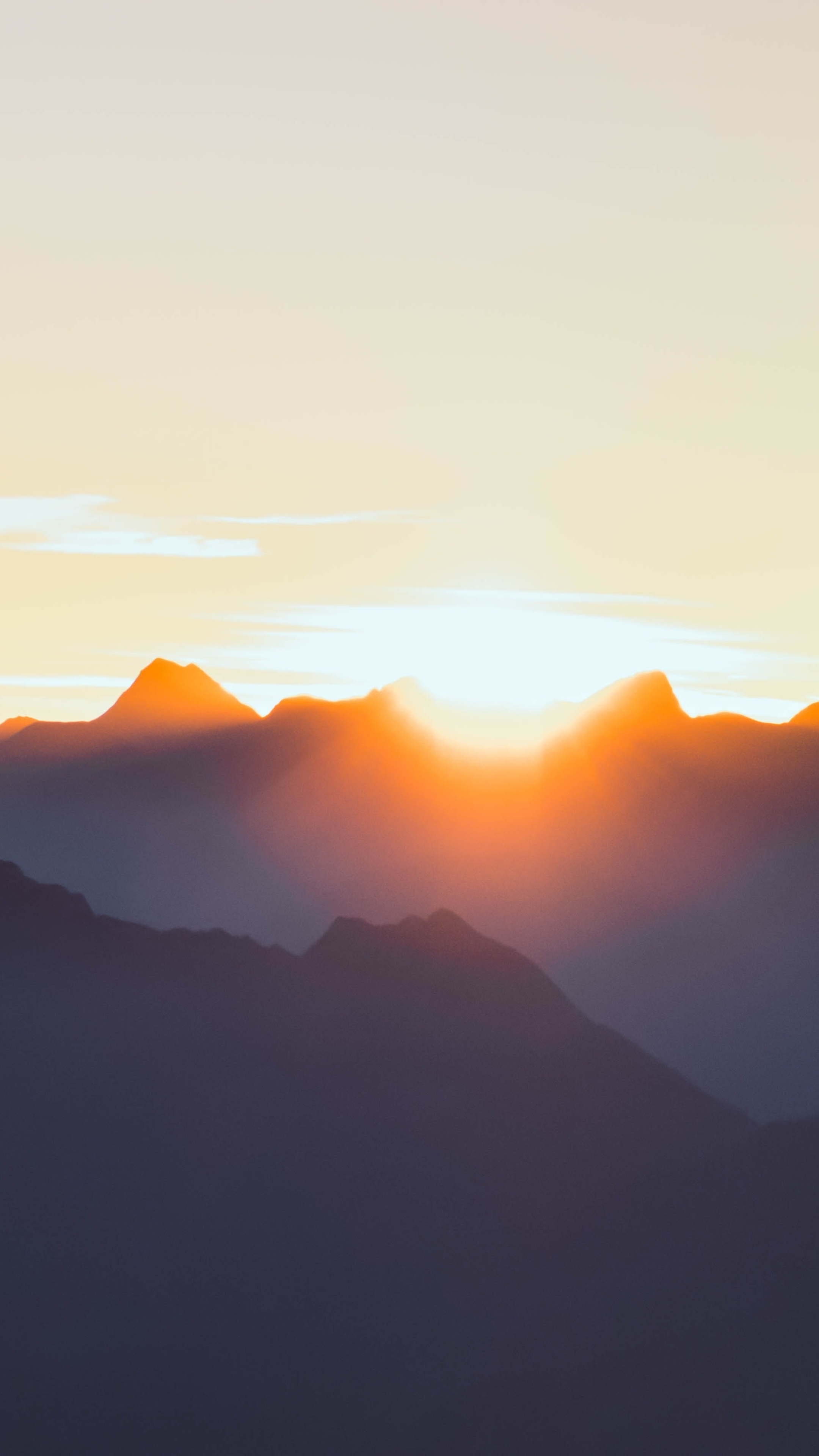Mountains at sunrise with orange sun peeking through HD Phone Wallpaper
