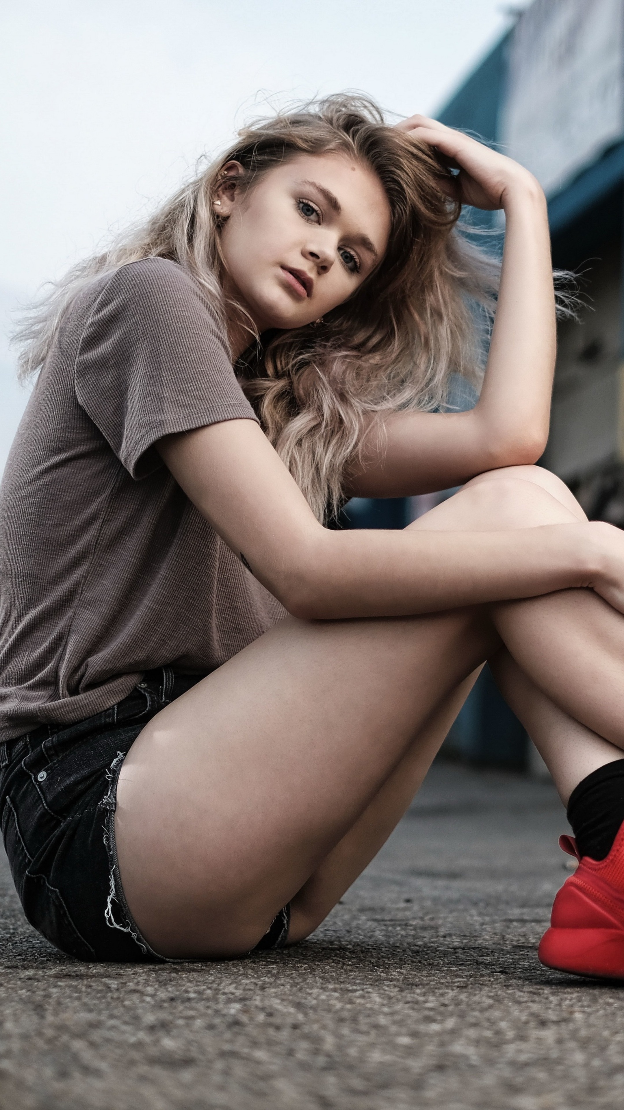 Young woman with blonde hair wearing a t-shirt and shorts HD Phone Wallpaper