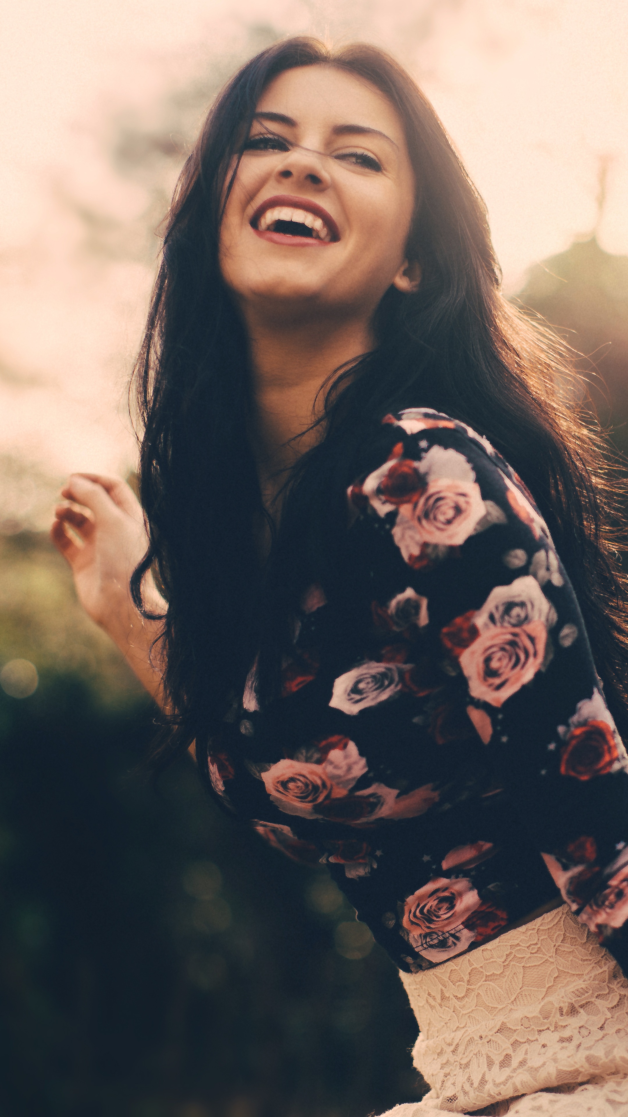 Young woman with dark hair smiling outdoors HD Phone Wallpaper