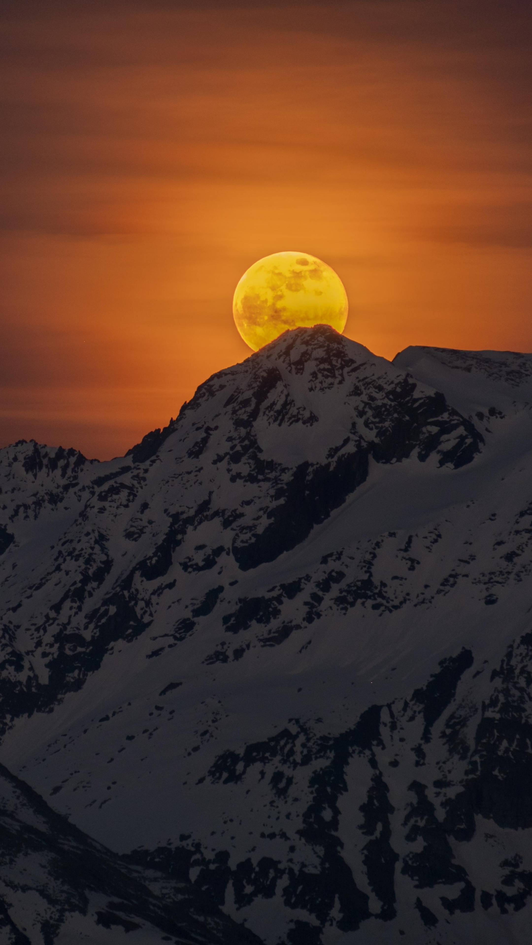 Full moon rising over snow-capped mountains at sunset HD Phone Wallpaper