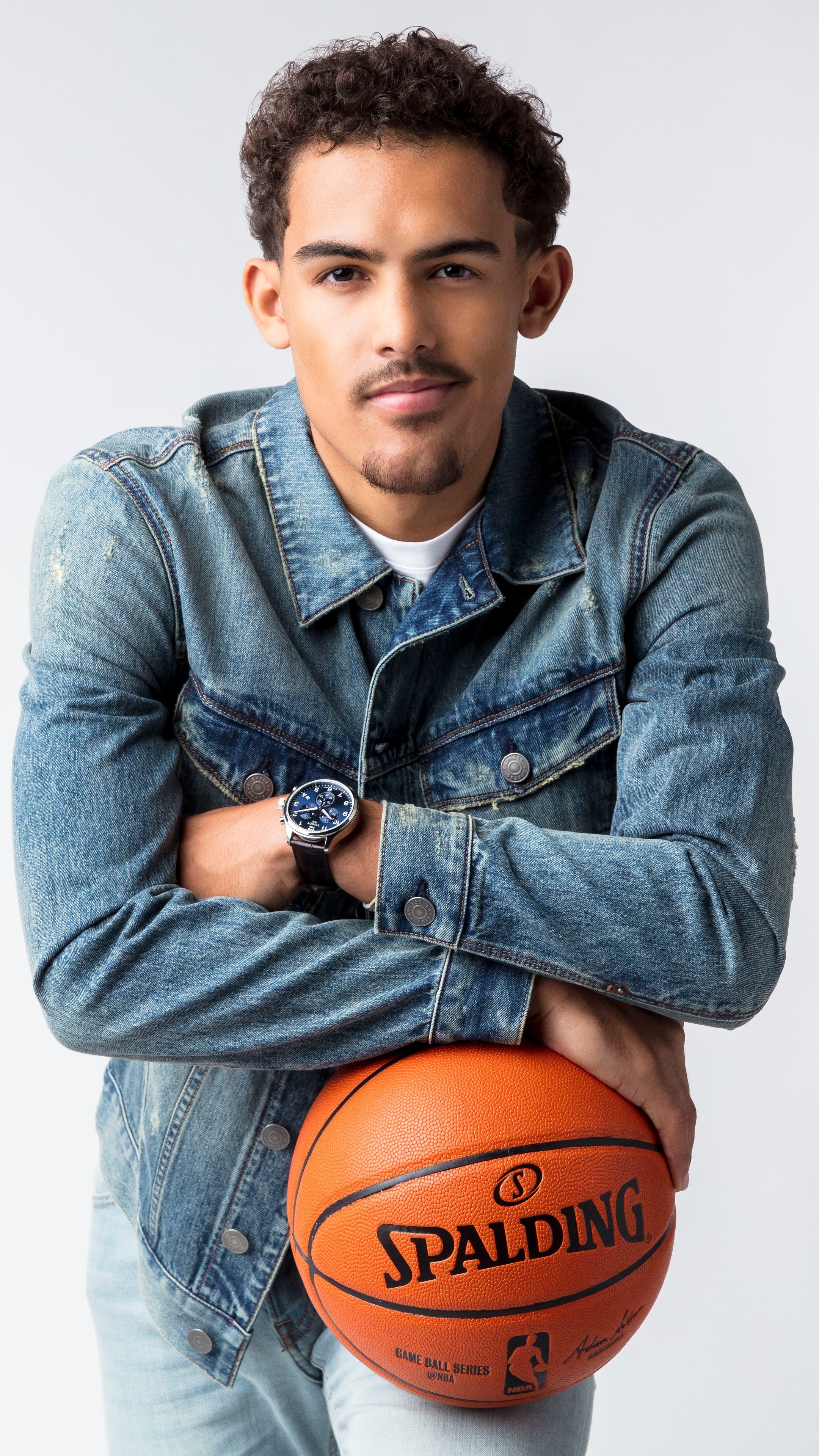 Trae Young from NBA holding a Spalding basketball HD Phone Wallpaper