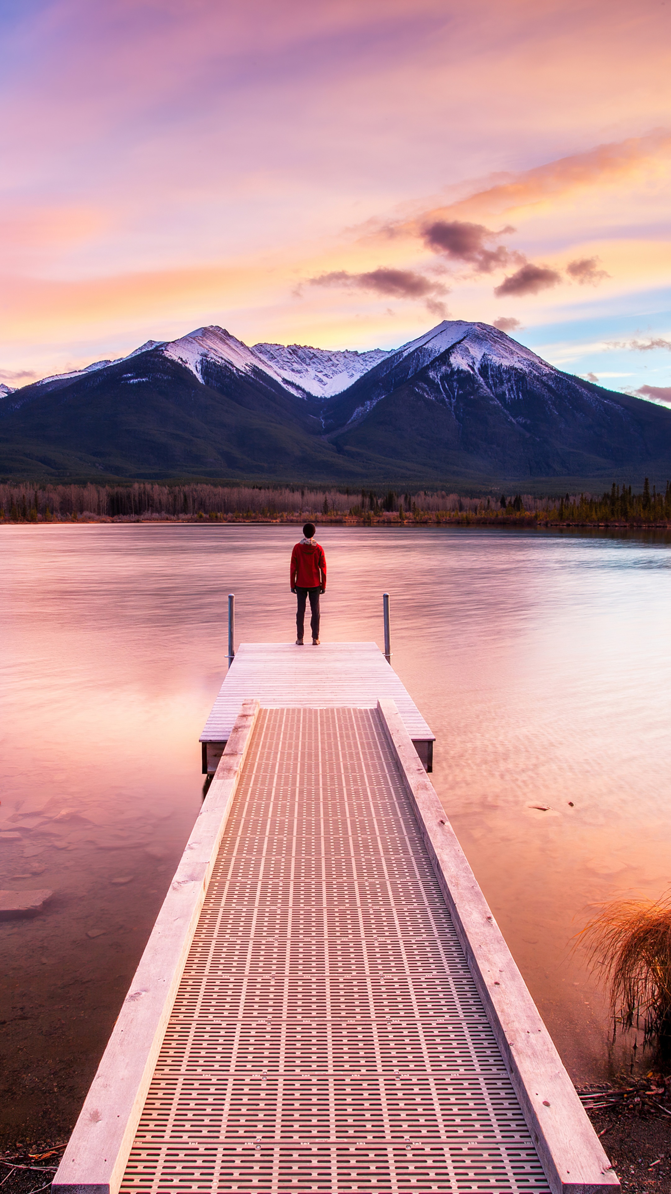 Man on pier at sunset with mountains HD Phone Wallpaper