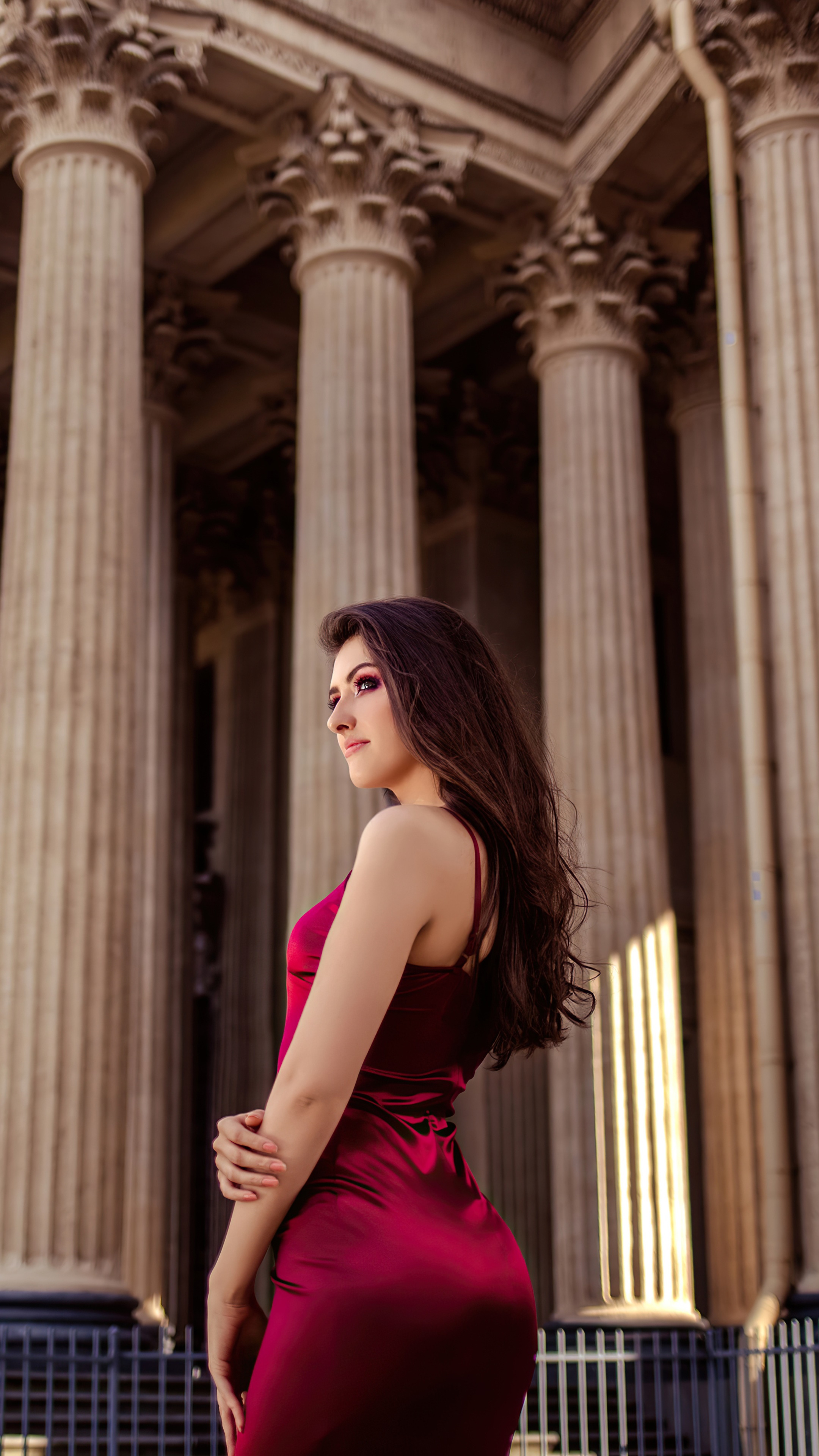 Woman in red dress in front of columns HD Phone Wallpaper