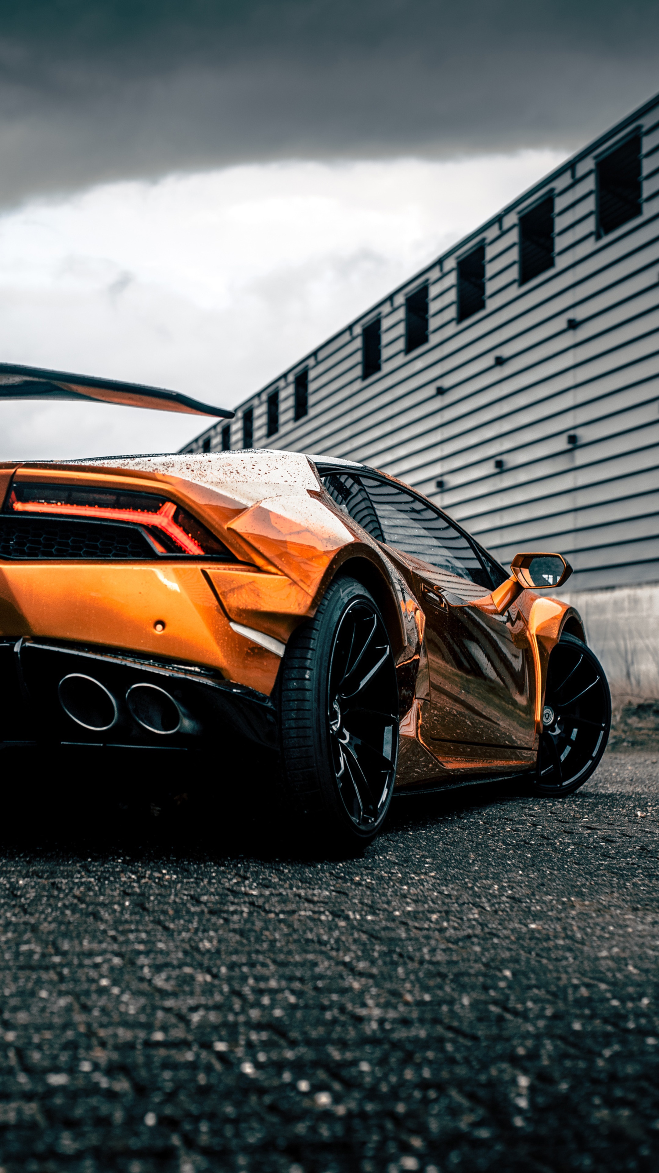 Orange Lamborghini Huracan parked near a building HD Phone Wallpaper