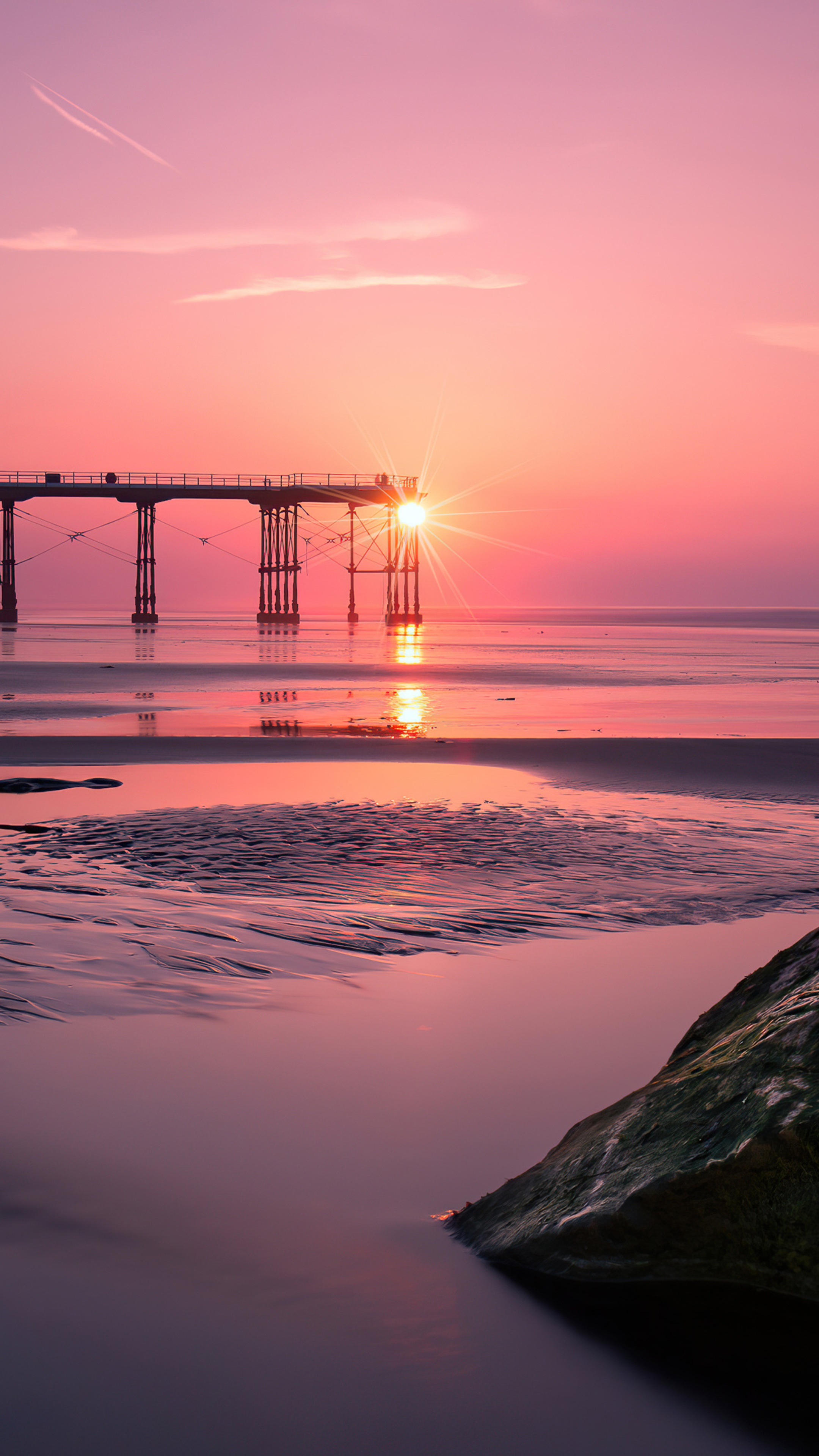Sunset over a pier at a beach HD Phone Wallpaper