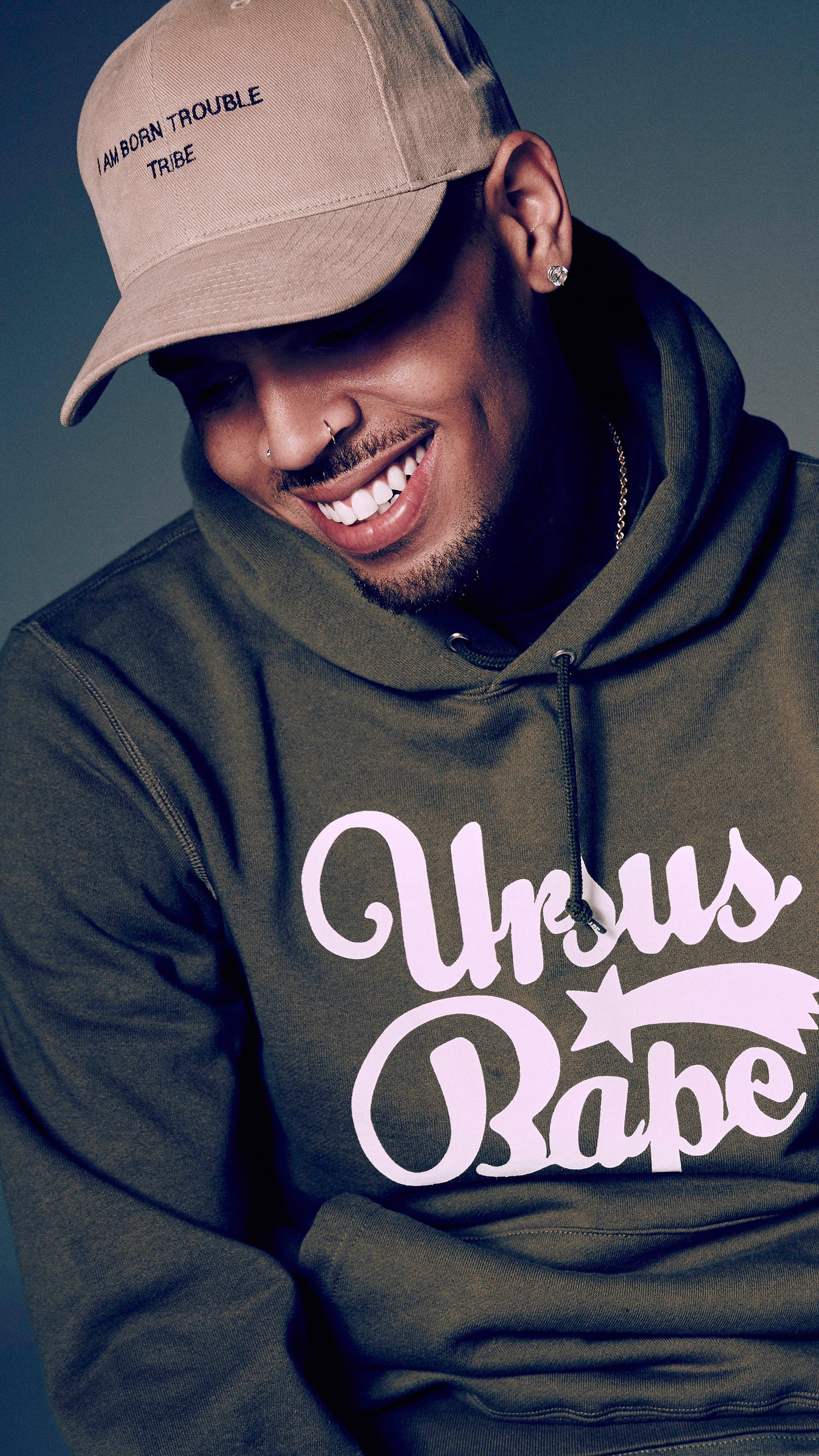 Chris Brown wearing a hoodie and baseball cap HD Phone Wallpaper