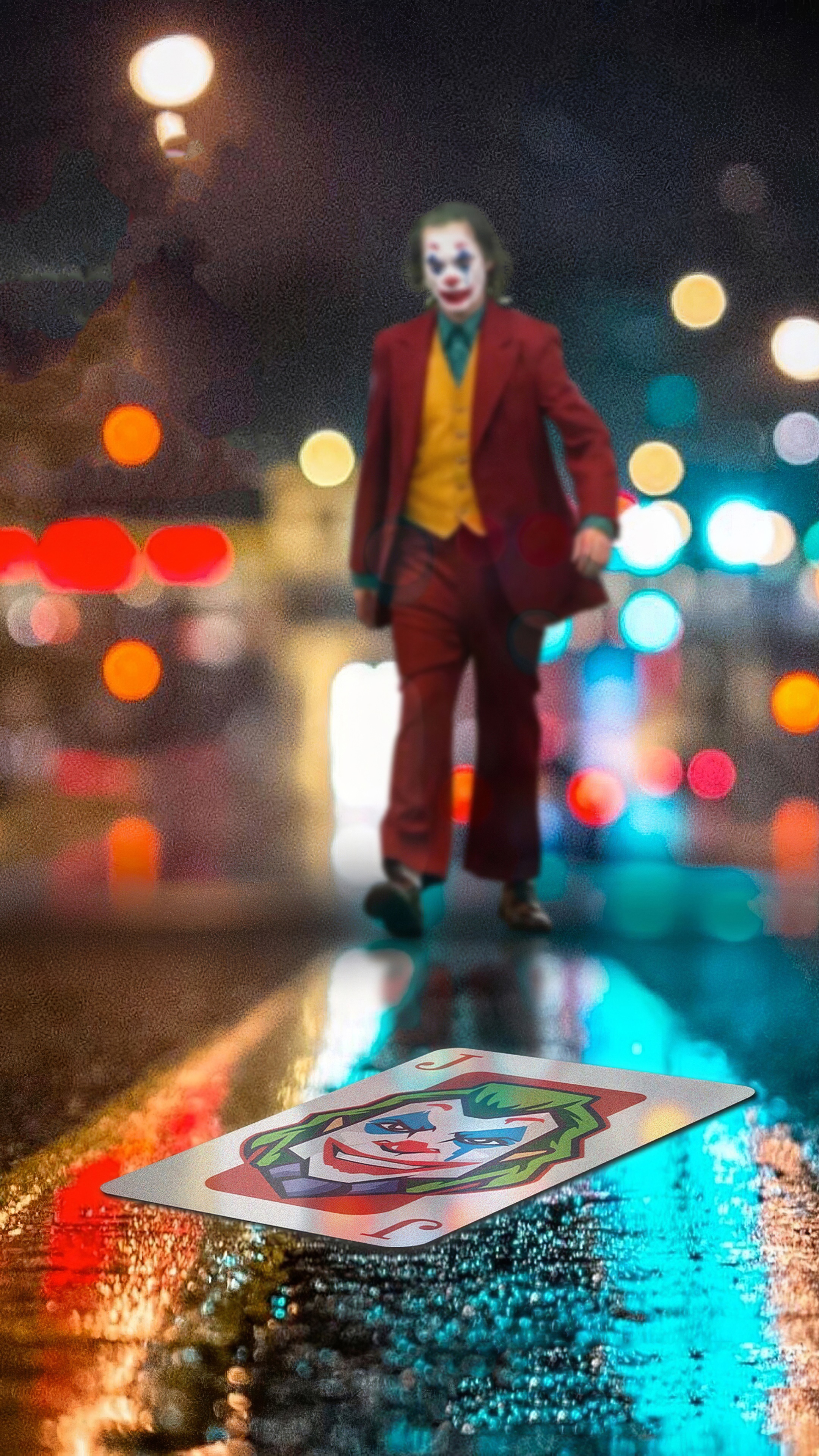 Joker walking on wet street with playing card HD Phone Wallpaper