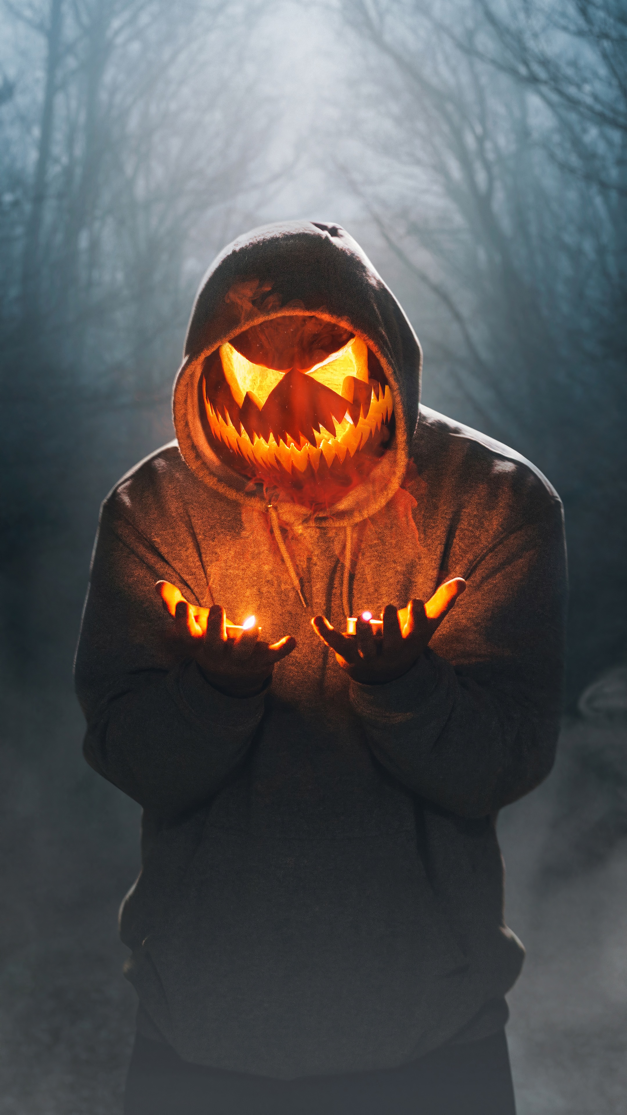 Person with Jack-o'-lantern mask holding candles HD Phone Wallpaper